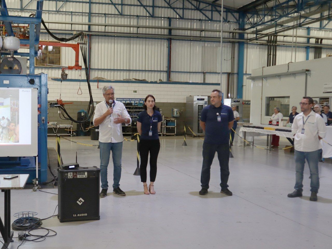 Um grupo de pessoas está em um armazém fazendo uma apresentação.