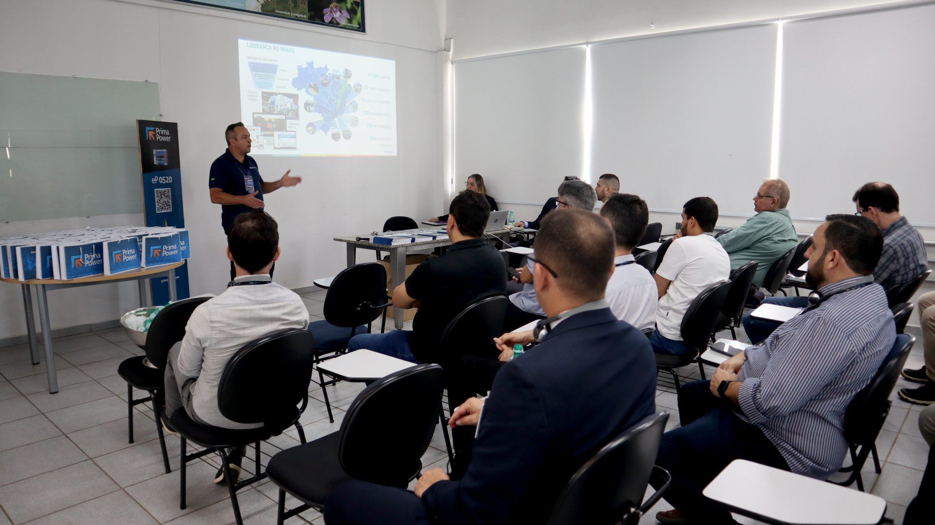 Um homem está fazendo uma apresentação para um grupo de pessoas em uma sala de aula.