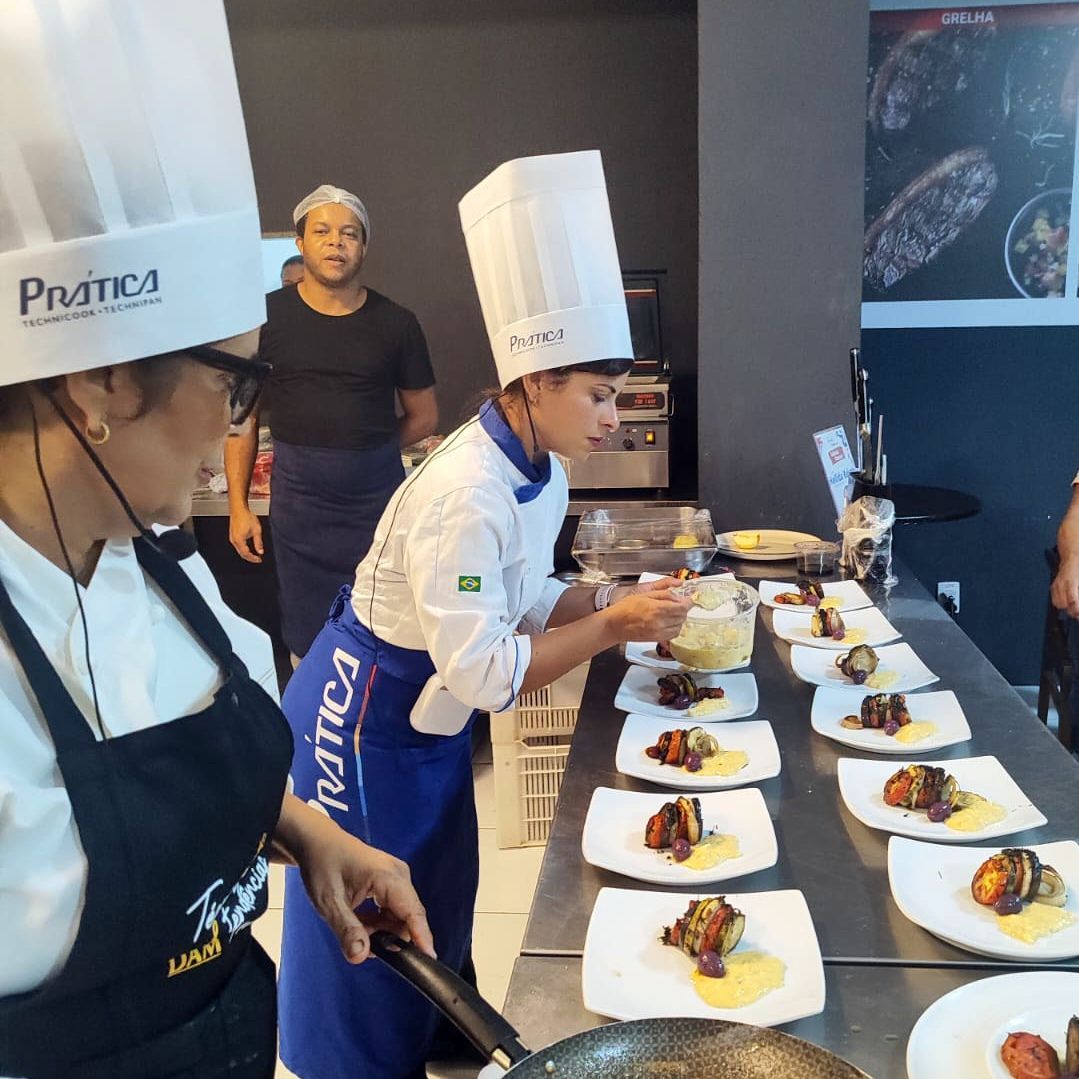 Um grupo de chefs está preparando comida em uma cozinha