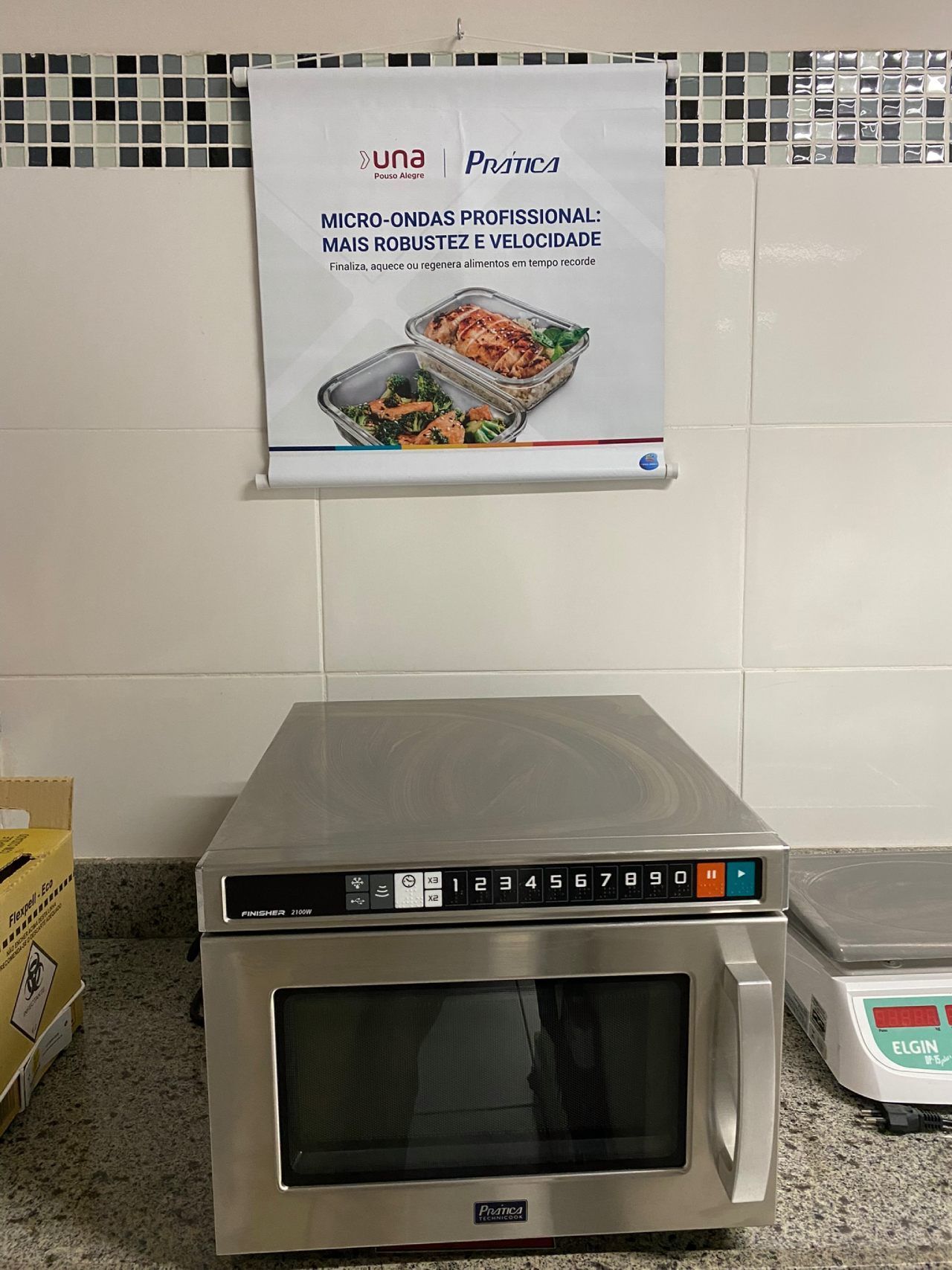 Um forno de micro-ondas está sobre um balcão ao lado de uma balança.