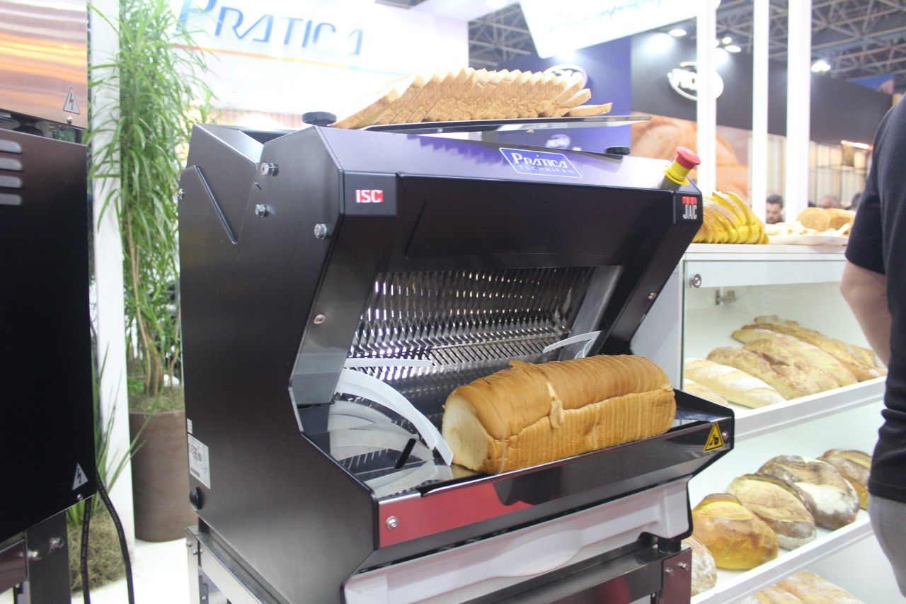 Um pão está sendo cortado em uma máquina