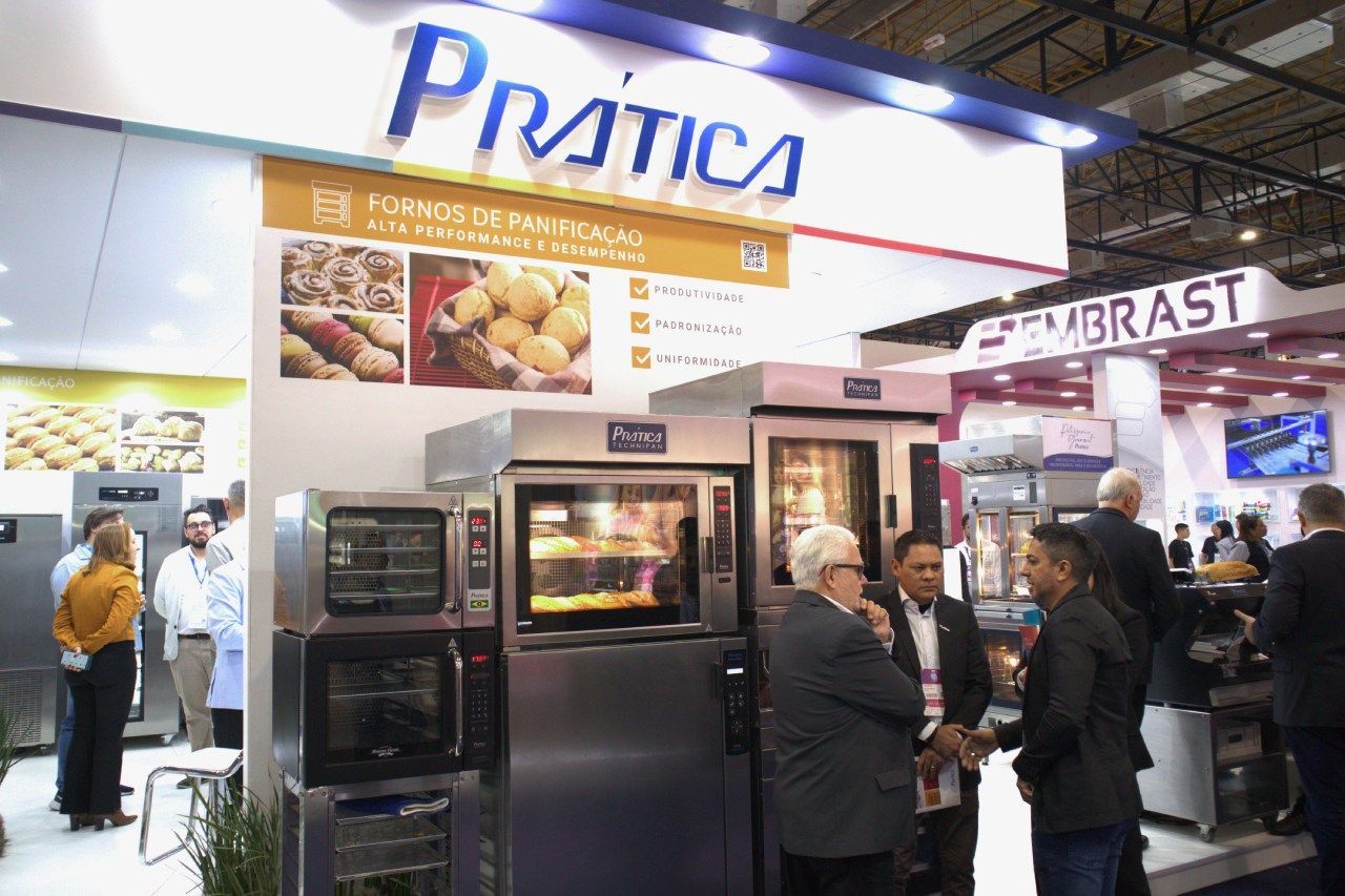 Um grupo de pessoas está em frente a uma exposição de eletrodomésticos.