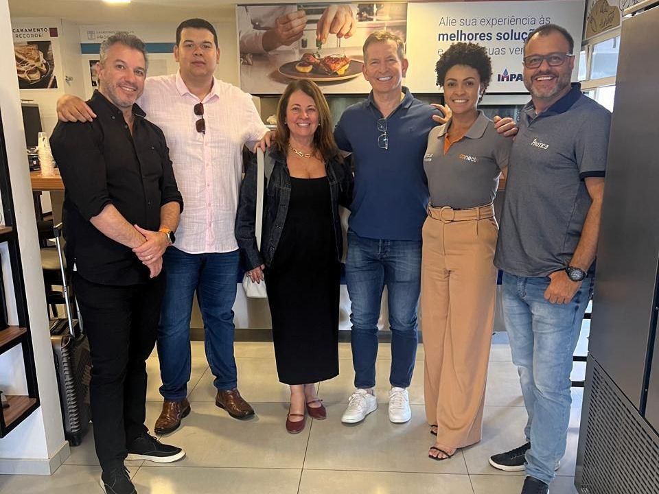 Um grupo de pessoas está posando para uma foto em uma cozinha.