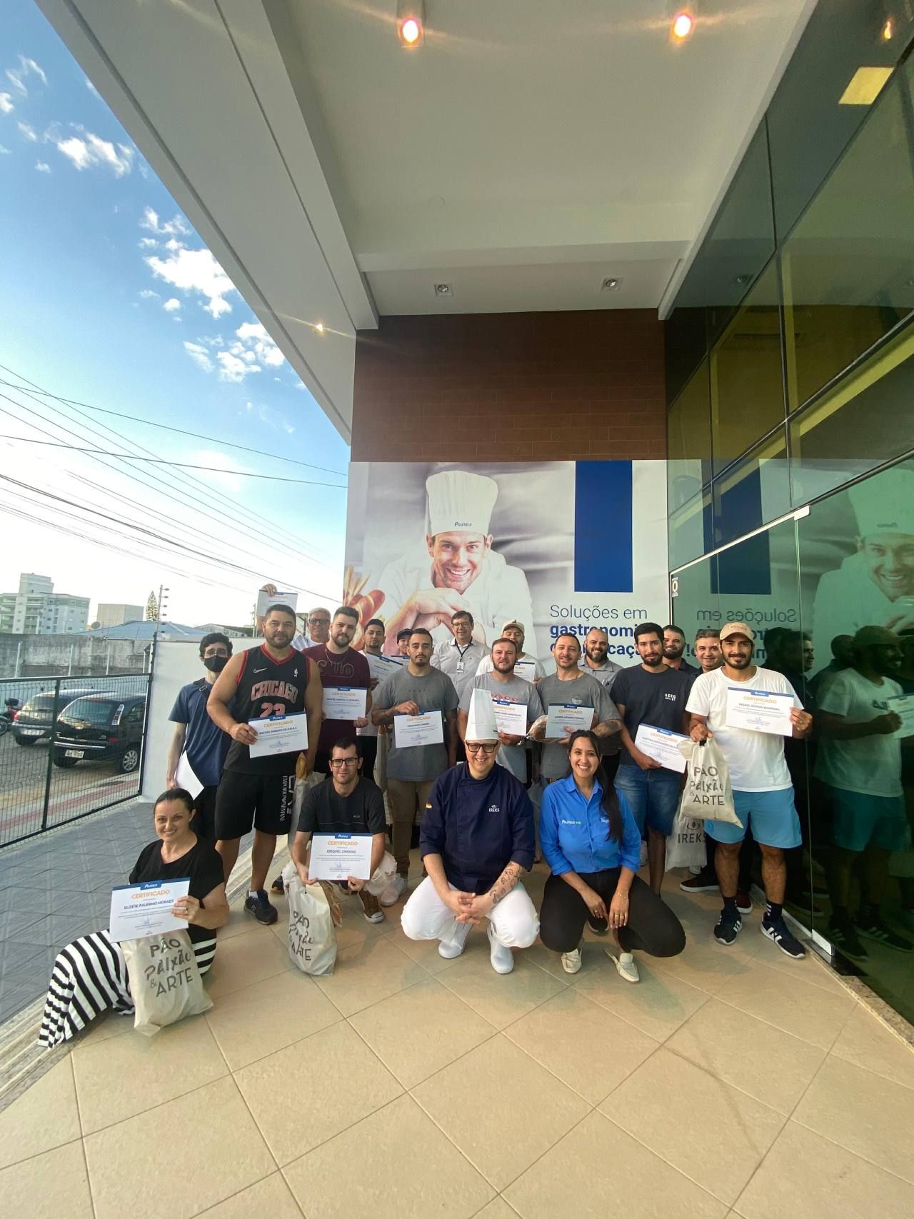 Um grupo de pessoas está posando para uma foto em frente a um prédio.