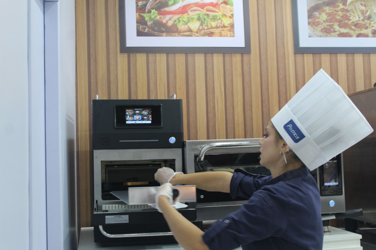 Uma mulher com chapéu de chef está trabalhando em uma cozinha
