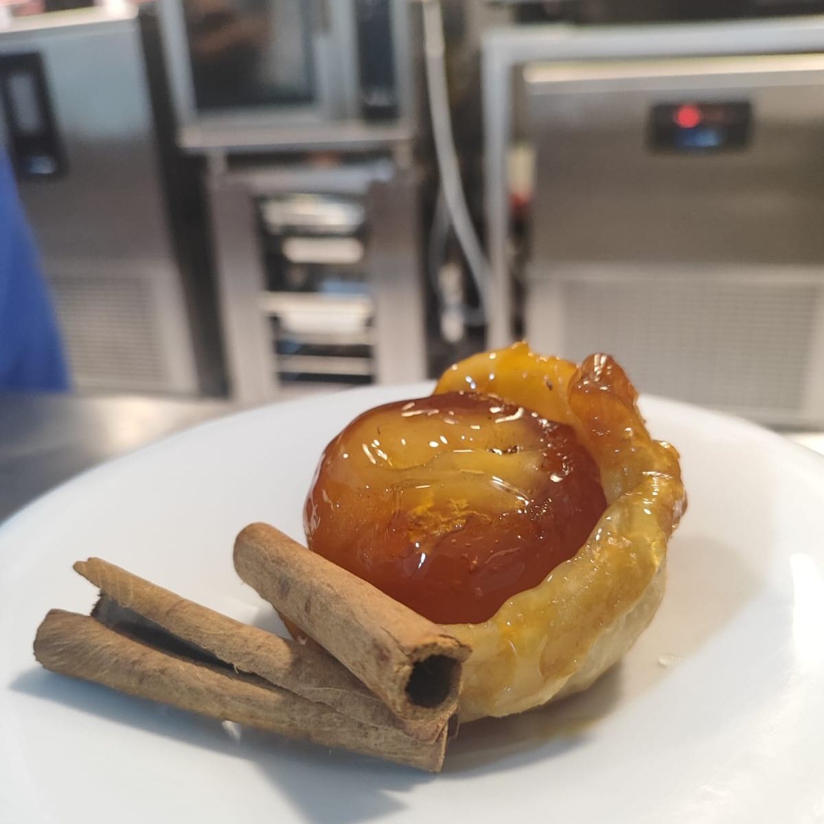 Um close de uma sobremesa com paus de canela em um prato branco