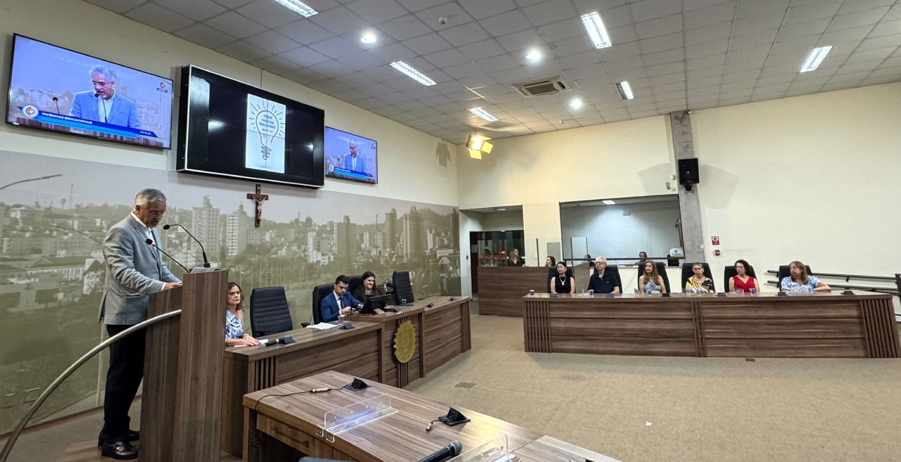 Um homem está fazendo um discurso para um grupo de pessoas em uma sala de conferências.