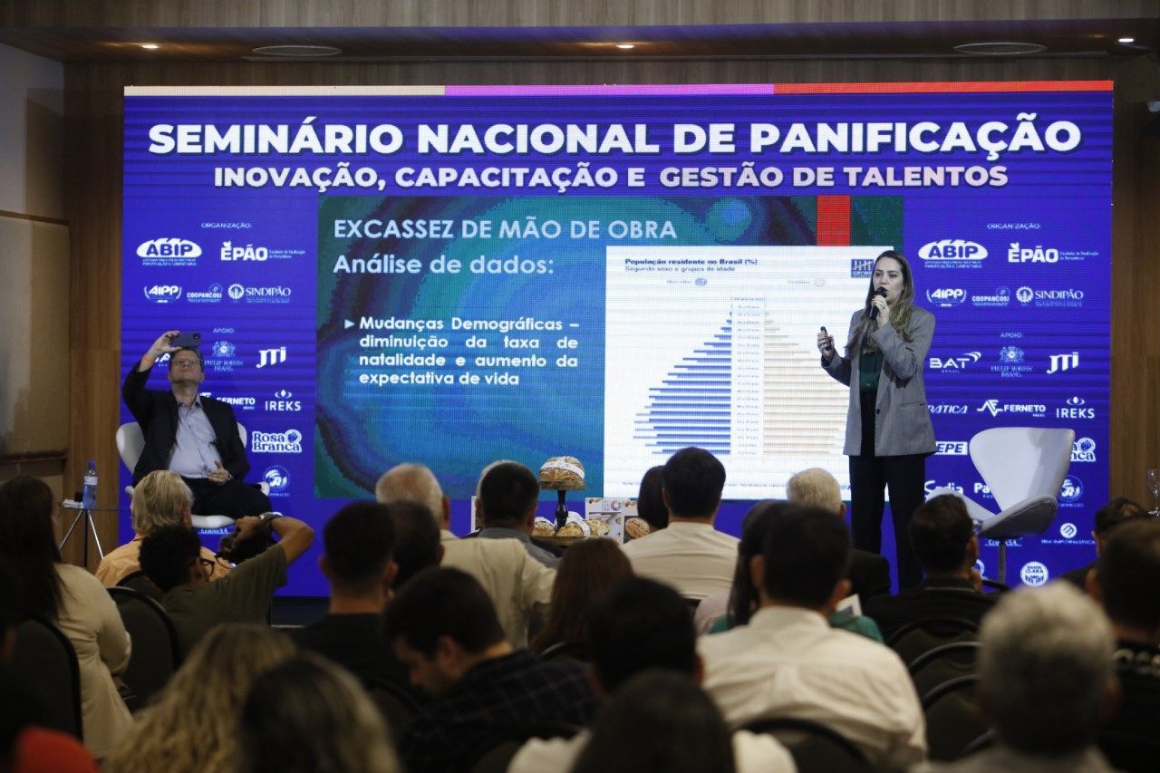 Uma mulher está fazendo uma apresentação para uma multidão em um seminário