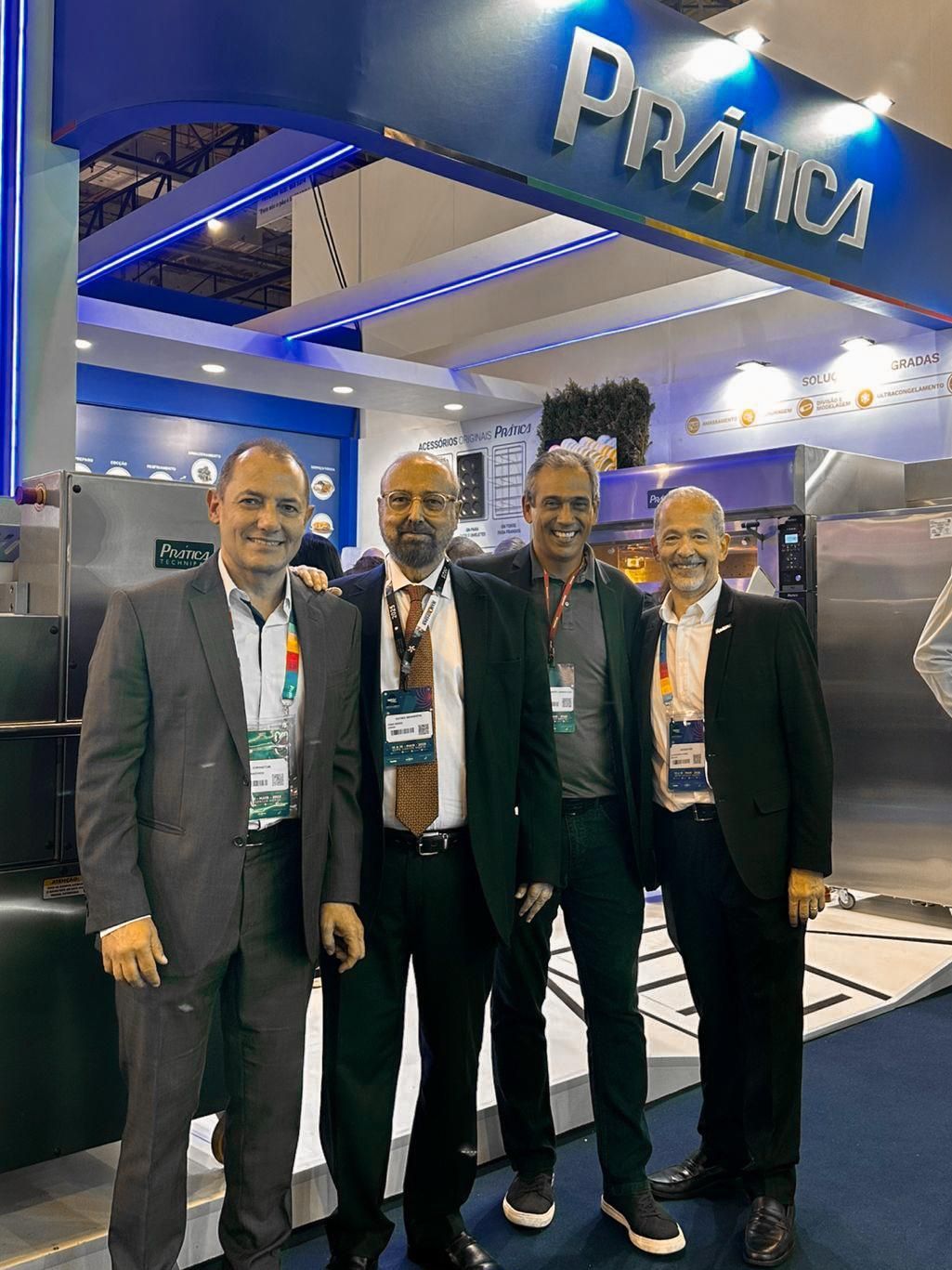 Um grupo de homens está posando para uma foto em uma convenção.