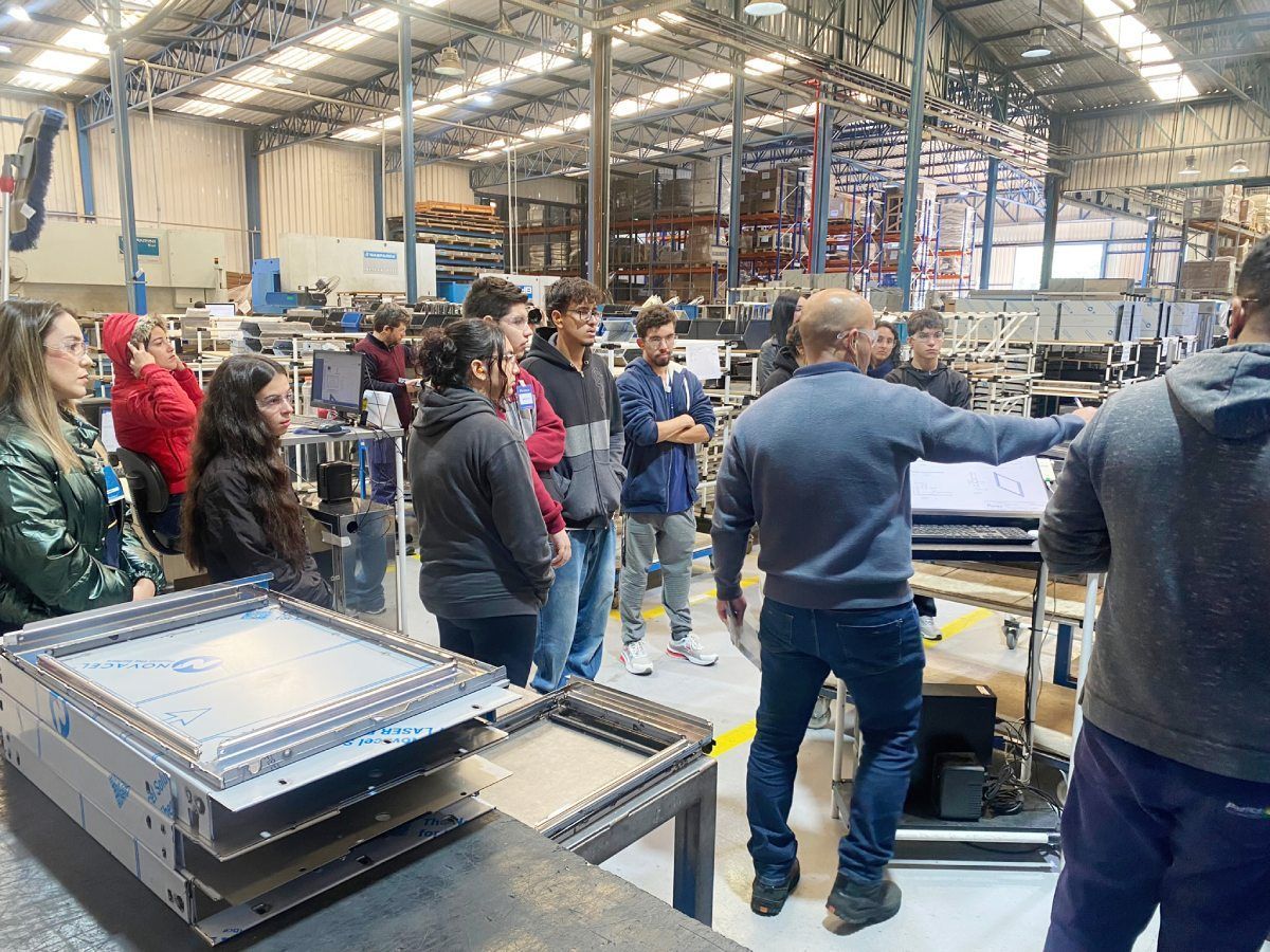 Um grupo de pessoas está em um armazém conversando entre si.