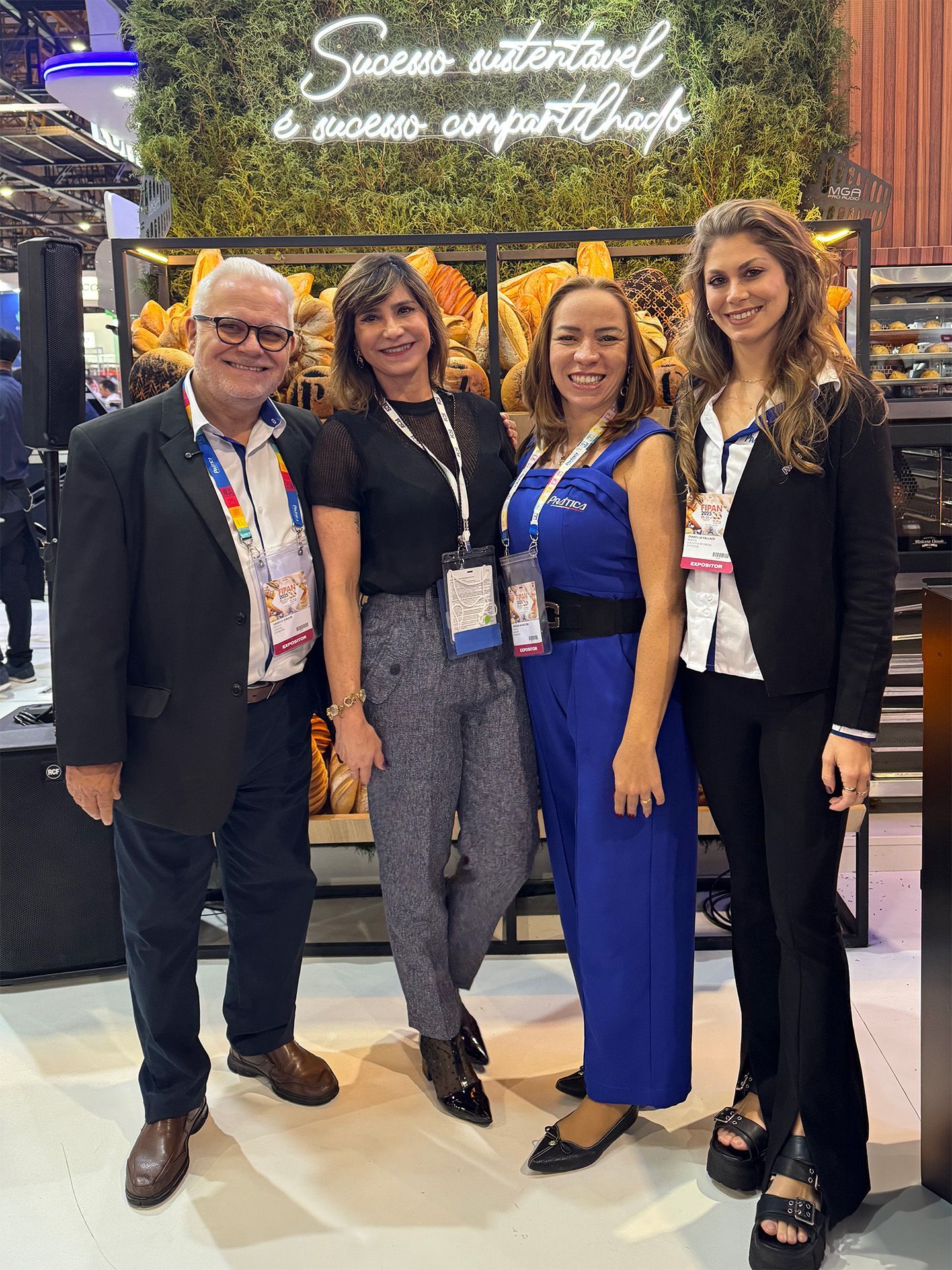 Um grupo de pessoas está posando para uma foto em frente a uma vitrine.