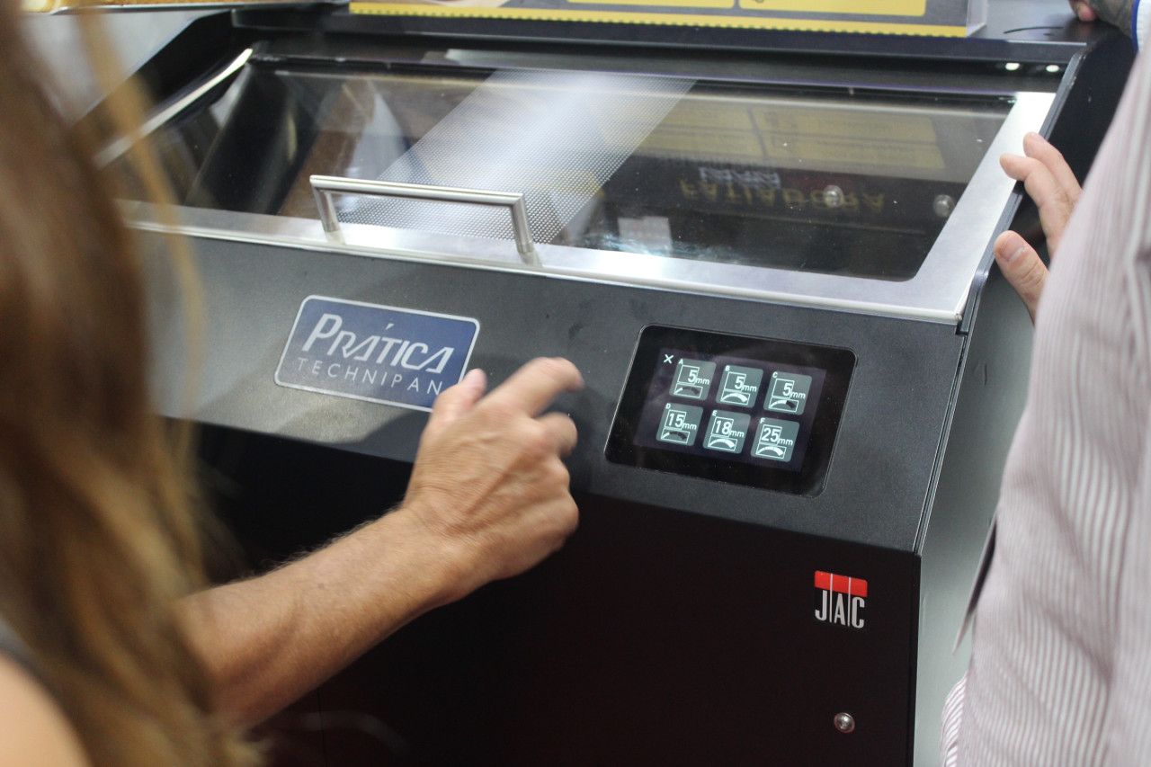 Uma mulher está apertando um botão em uma máquina que diz primo1