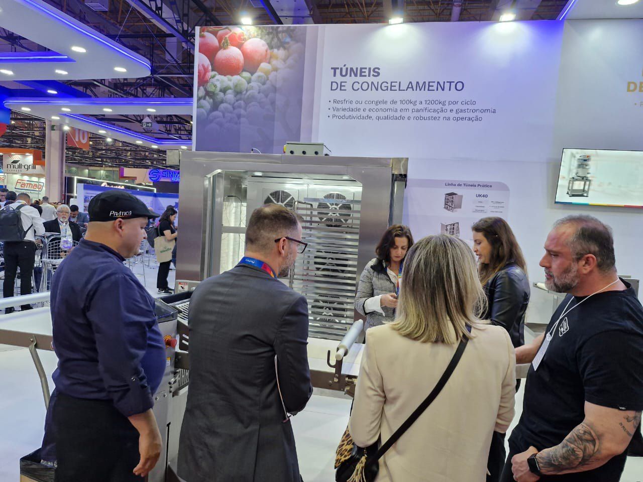 Um grupo de pessoas está em volta de uma máquina em uma convenção.