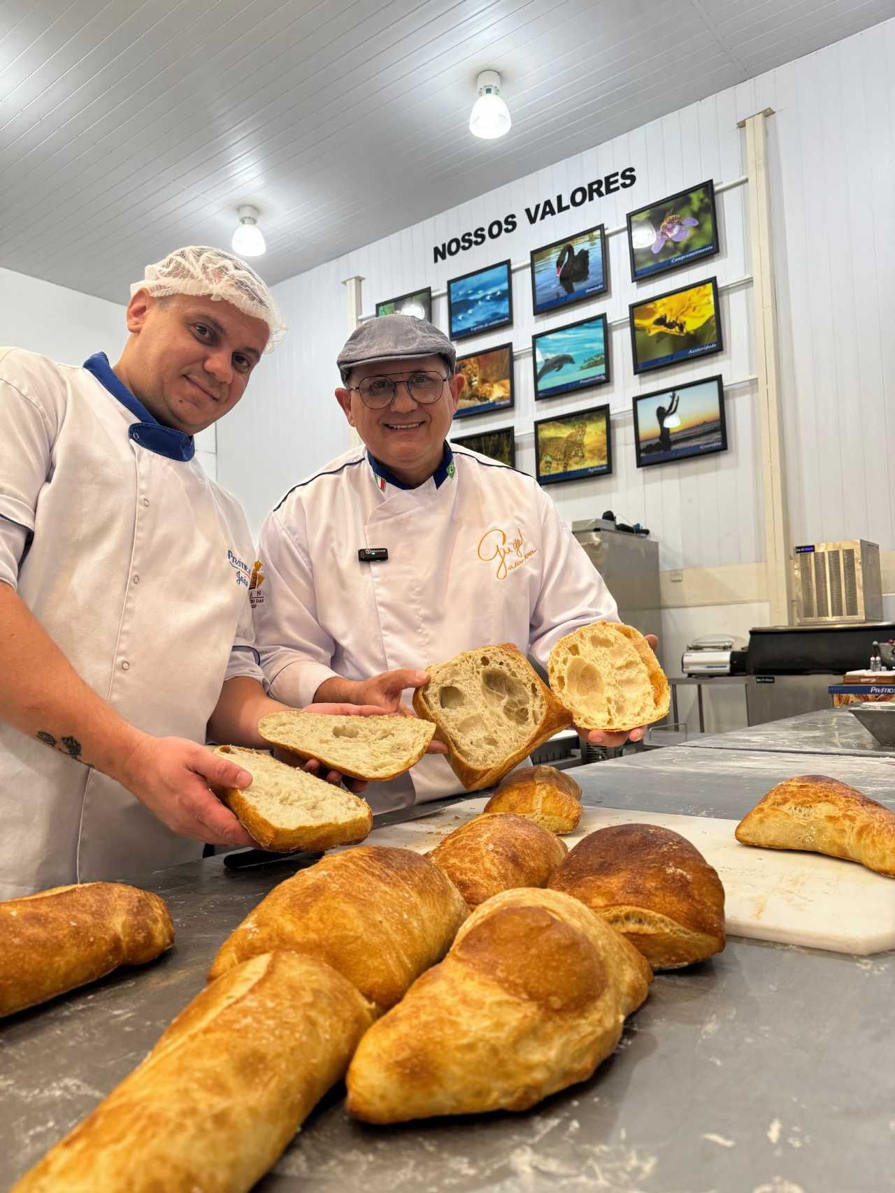 Dois homens estão segurando fatias de pão em uma padaria.