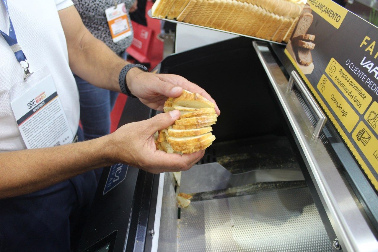 Um homem segura um pedaço de pão em frente ao forno.