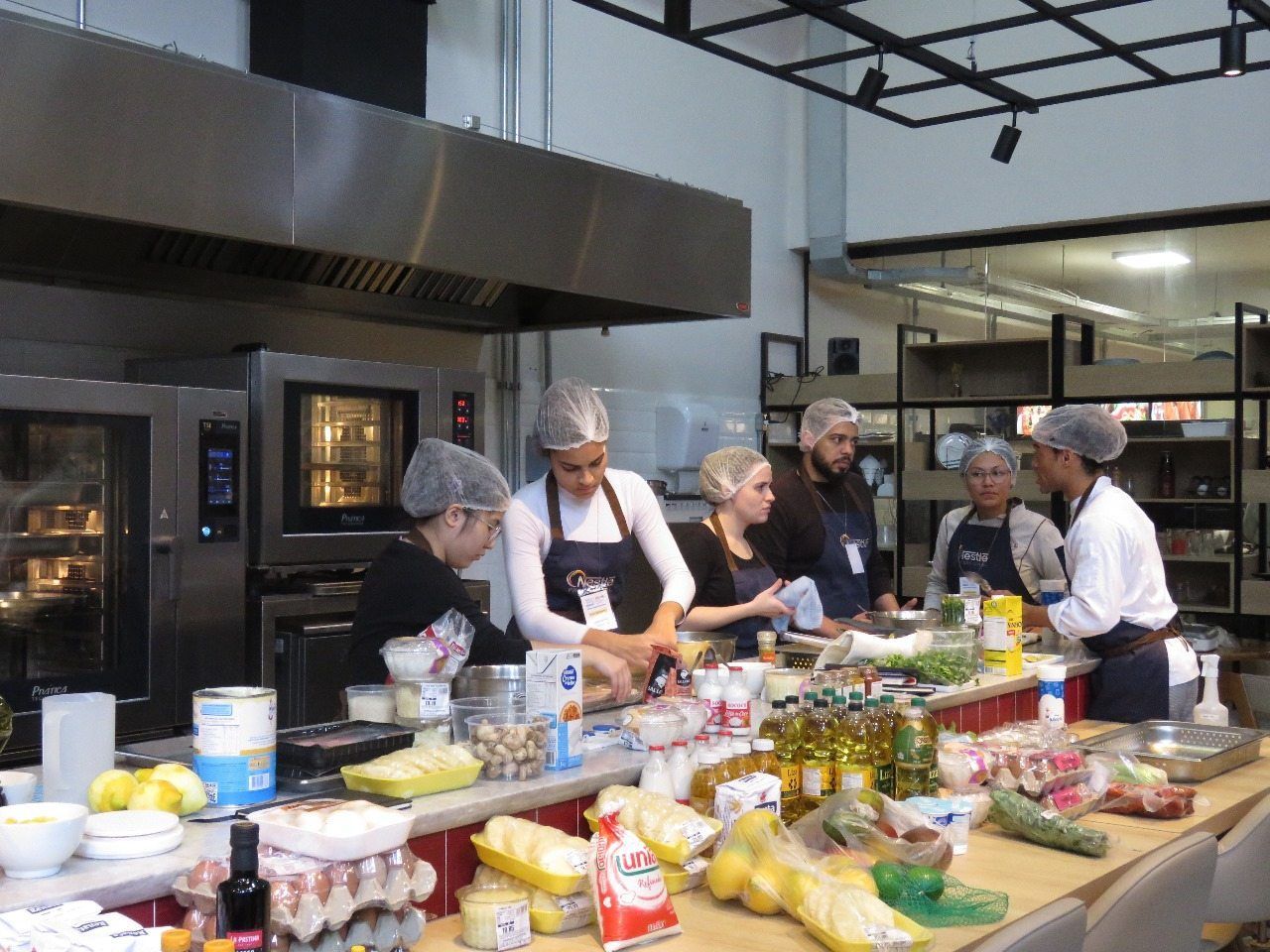 Um grupo de pessoas está preparando comida em uma cozinha.