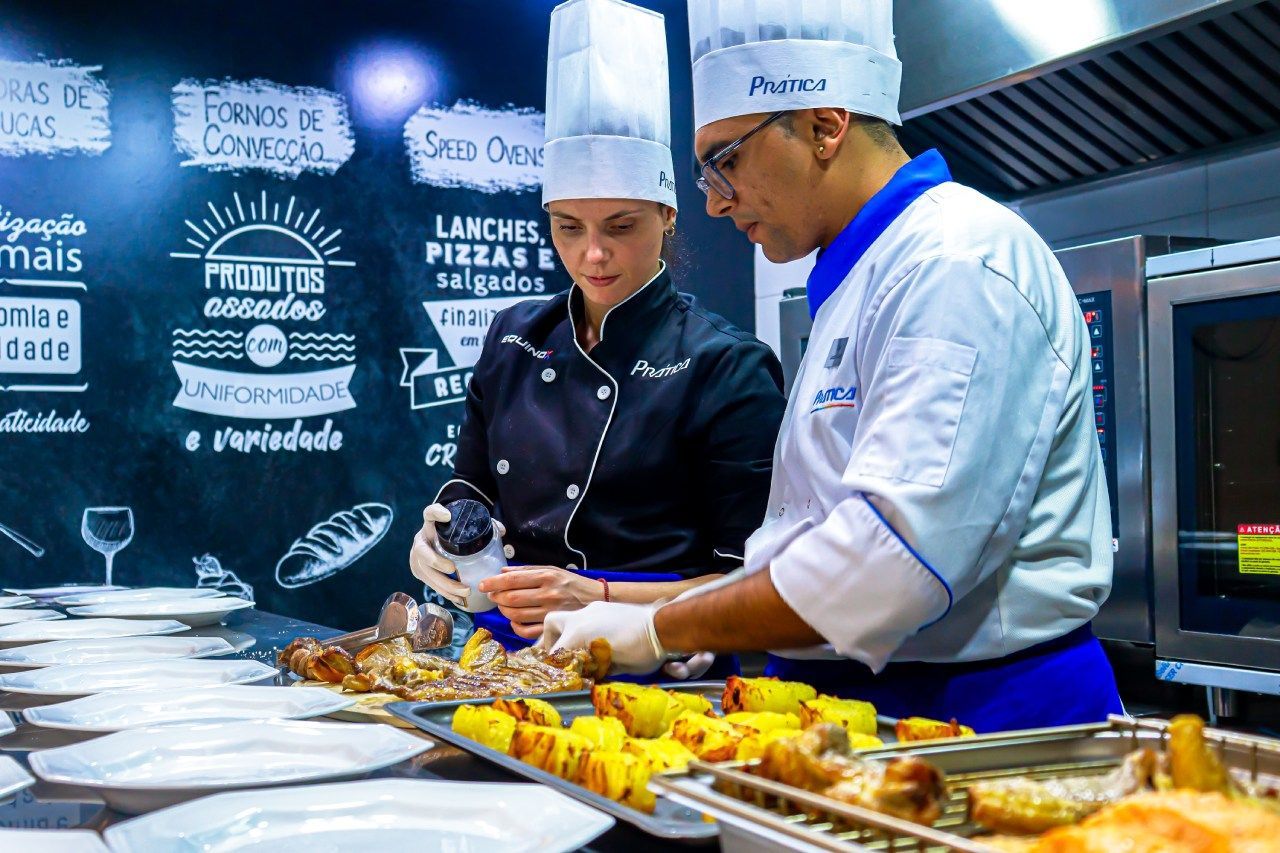 Um homem e uma mulher estão preparando comida na cozinha.