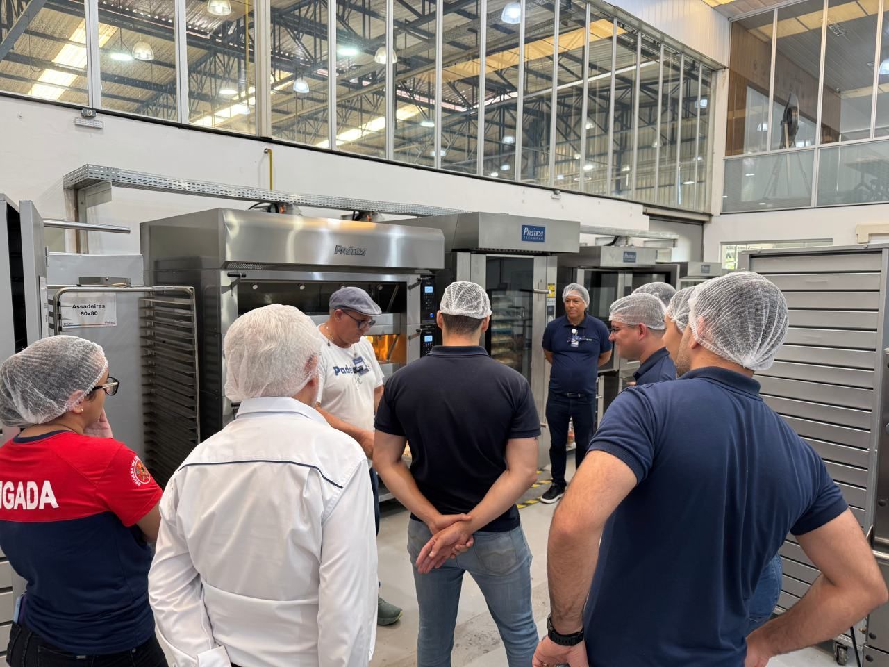 Um grupo de pessoas está em um armazém conversando entre si.