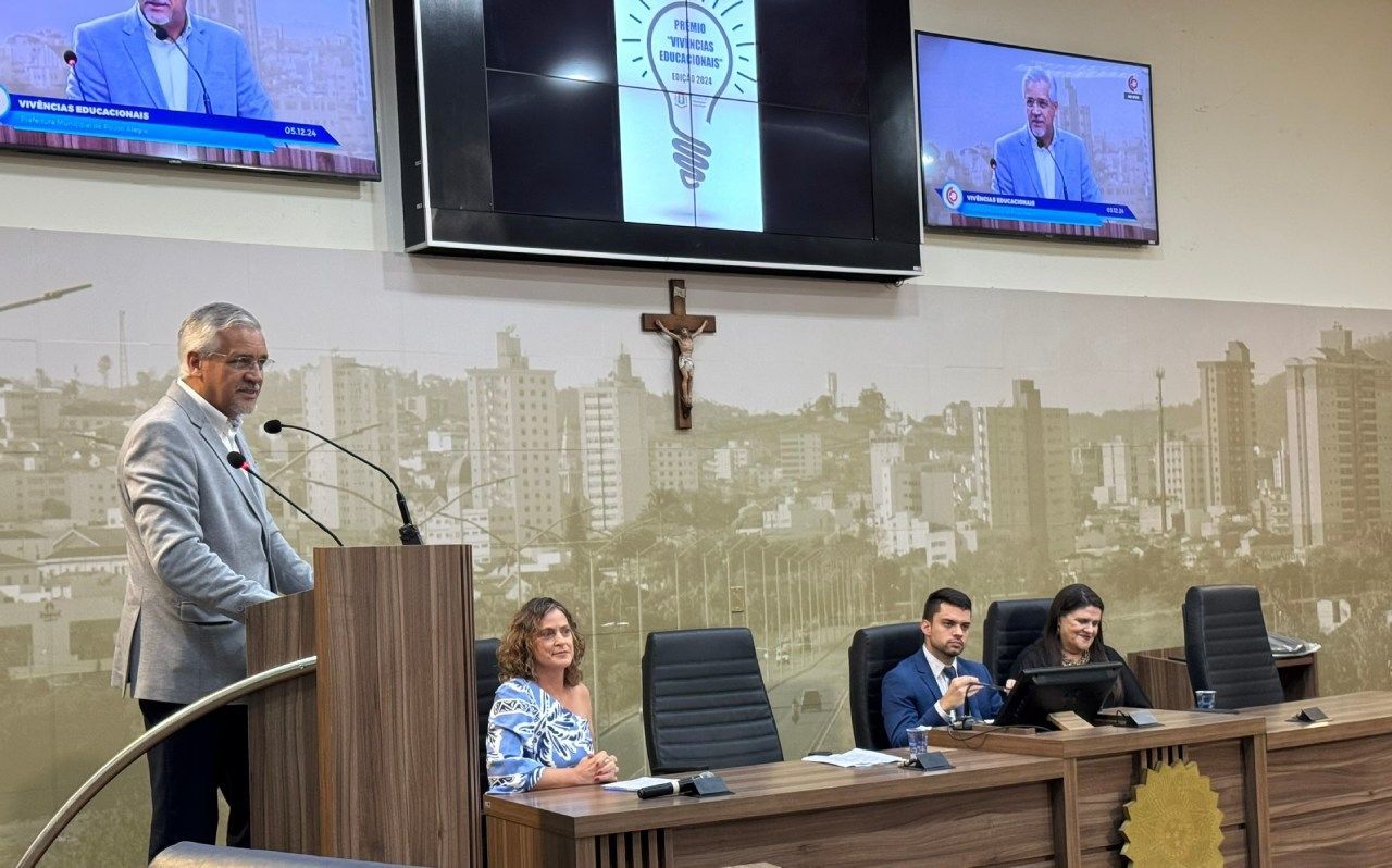 Um homem está em um pódio fazendo um discurso na frente de um grupo de pessoas.