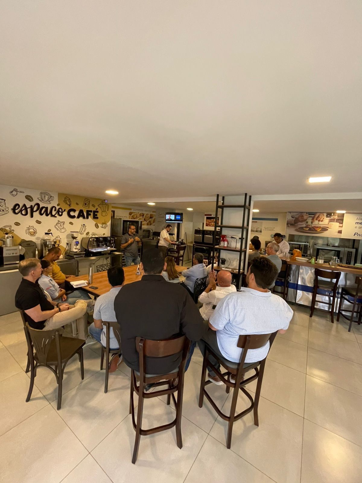 Um grupo de pessoas está sentado em mesas em um restaurante.