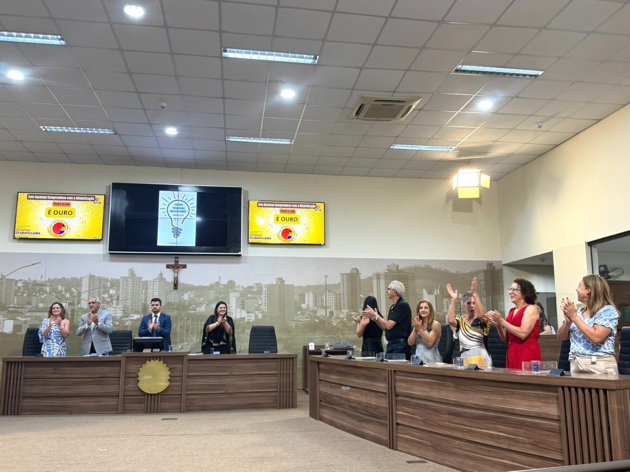 Um grupo de pessoas está aplaudindo em uma câmara do conselho.