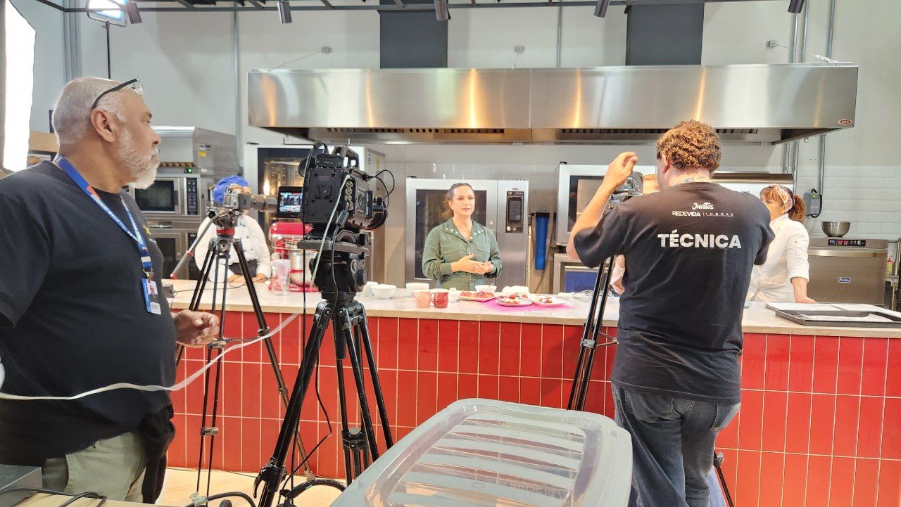 Um homem com uma camisa técnica está parado na frente de uma câmera