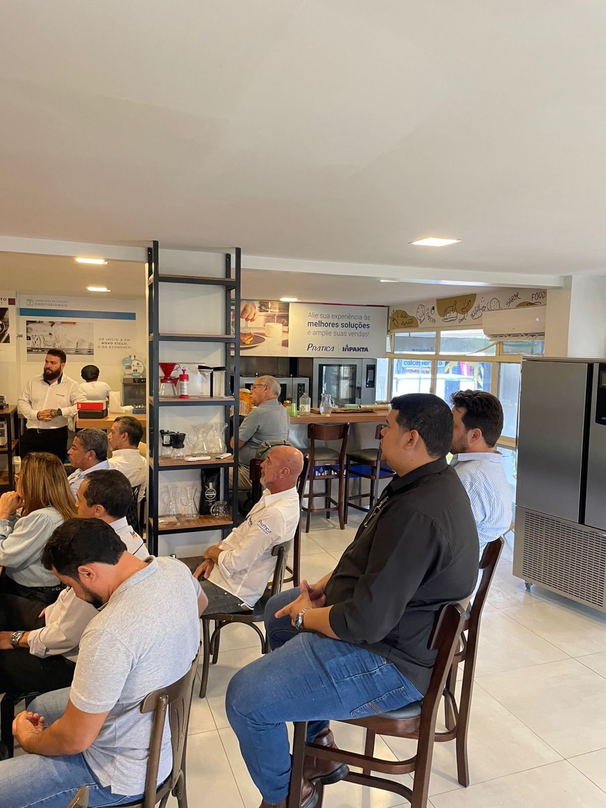 Um grupo de pessoas está sentado em cadeiras em um restaurante.