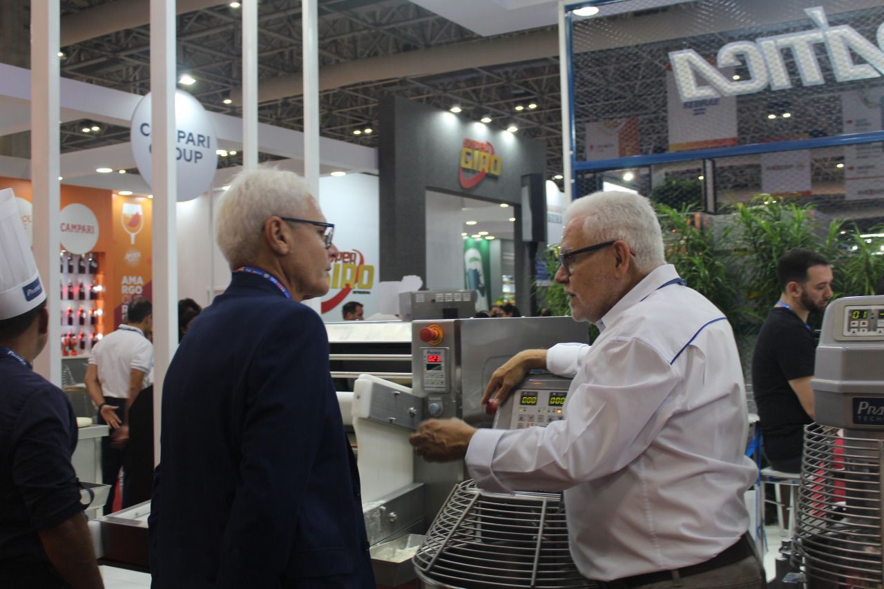 Um grupo de homens está ao redor de uma máquina em uma convenção.