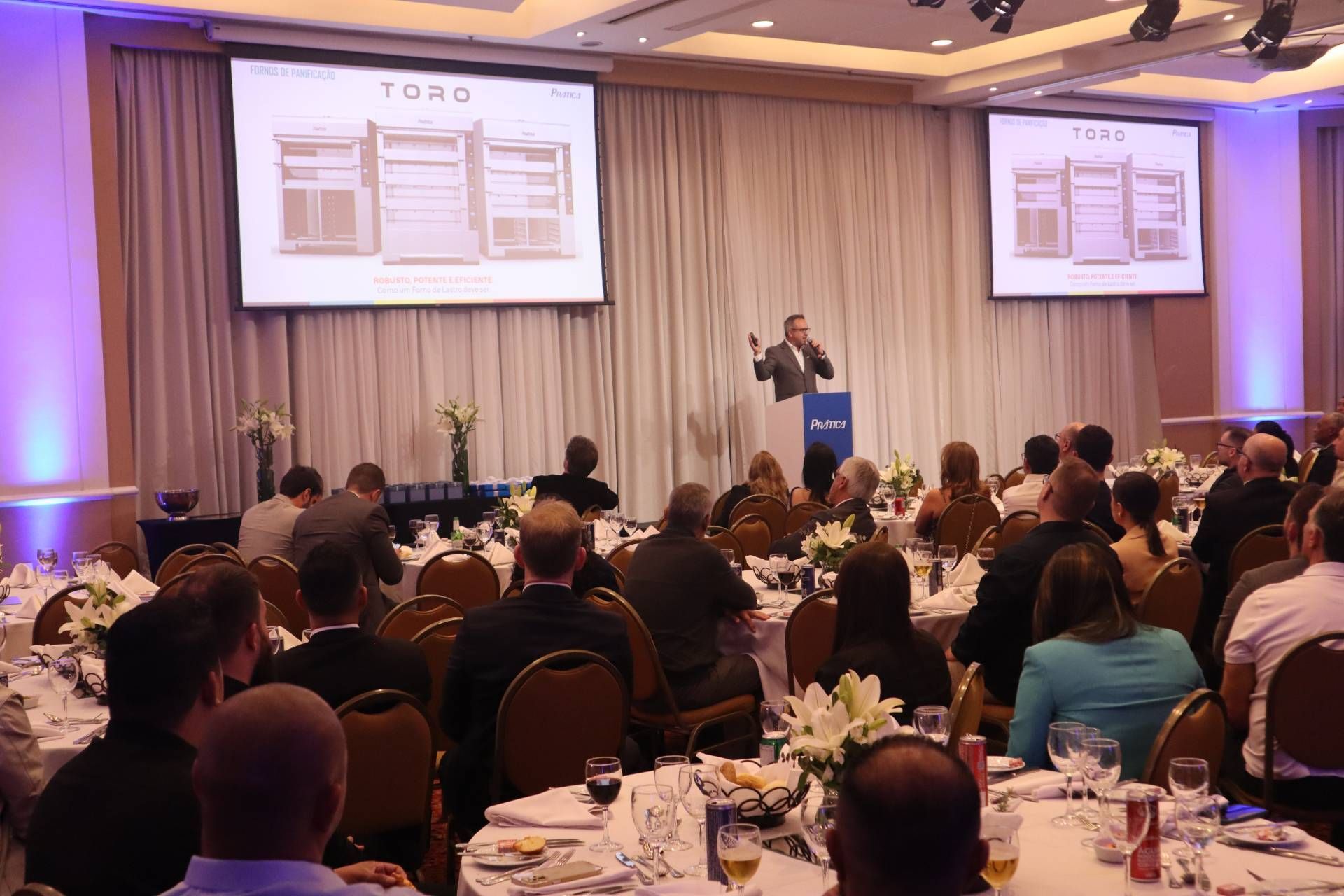 Um homem está fazendo uma apresentação para um grupo de pessoas em uma conferência.
