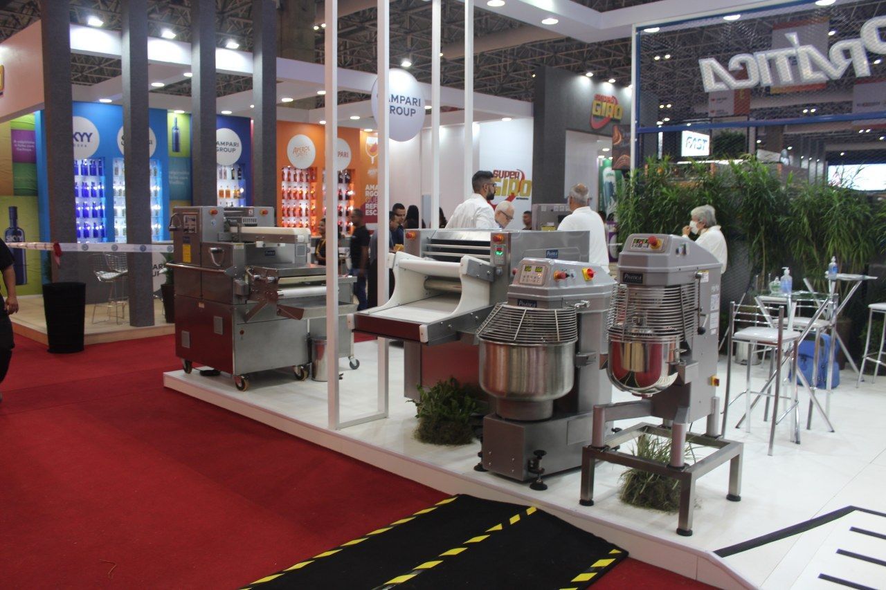 Um grupo de pessoas está em uma sala com muitas máquinas expostas.