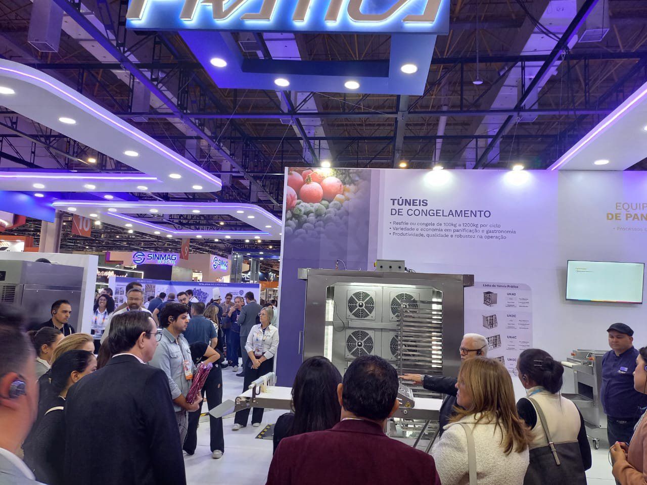 Um grupo de pessoas está em uma sala com uma placa que diz