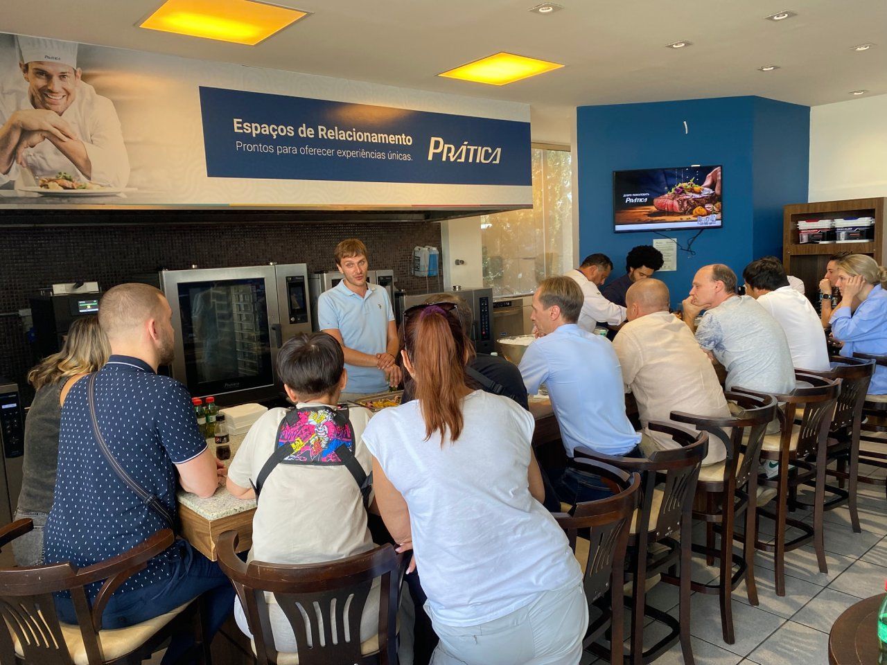 Um grupo de pessoas está sentado em mesas em um restaurante.