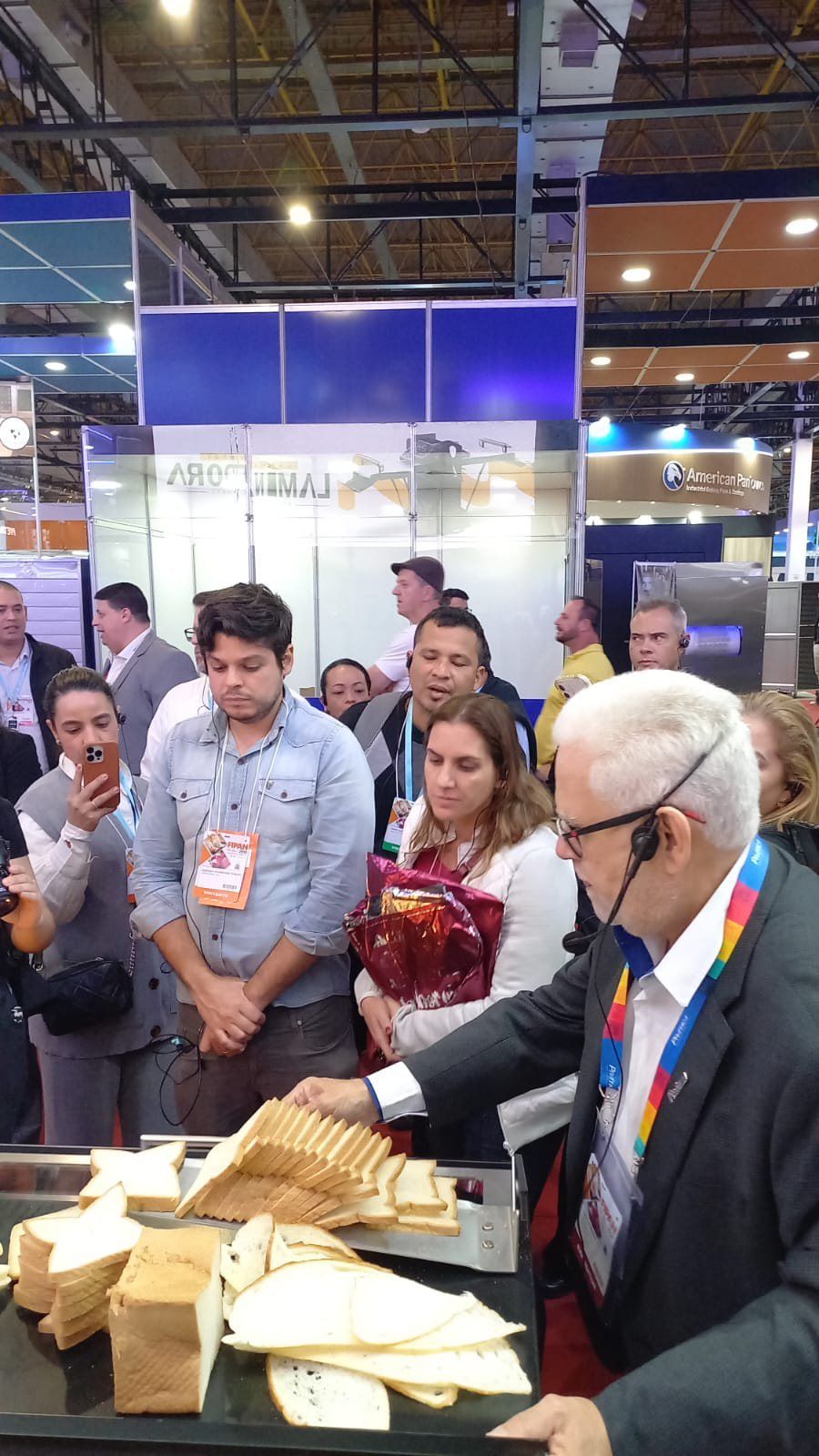Um homem de terno está parado em frente a uma mesa com sanduíches.
