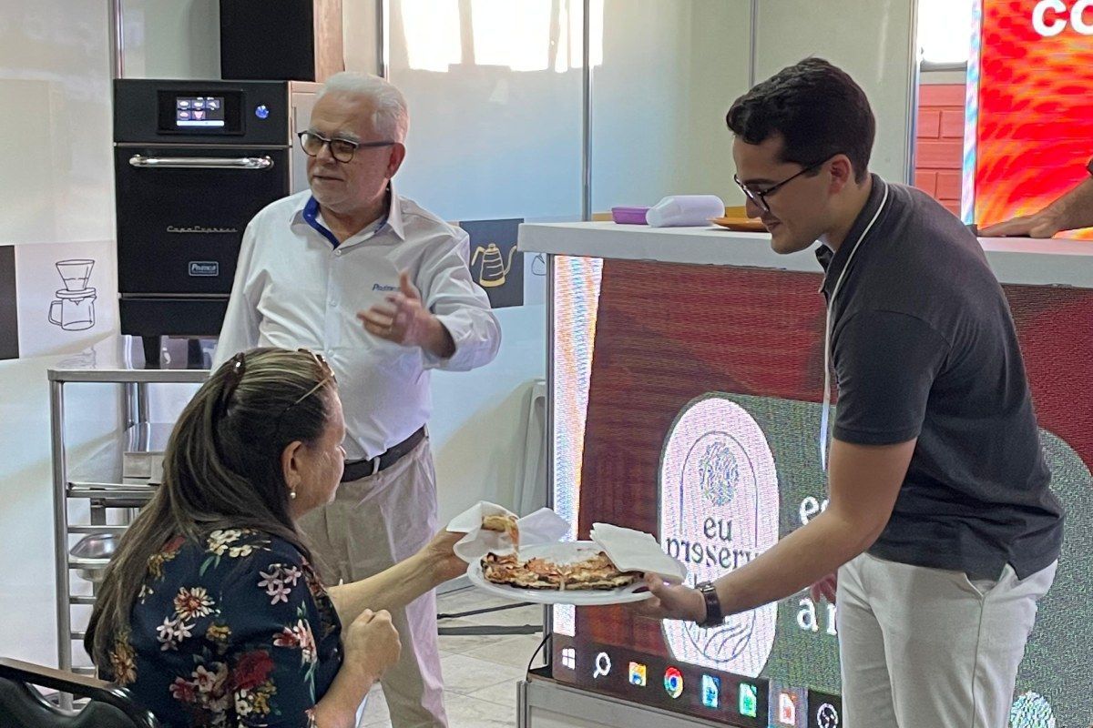 Um homem está servindo uma pizza para uma mulher em um restaurante.
