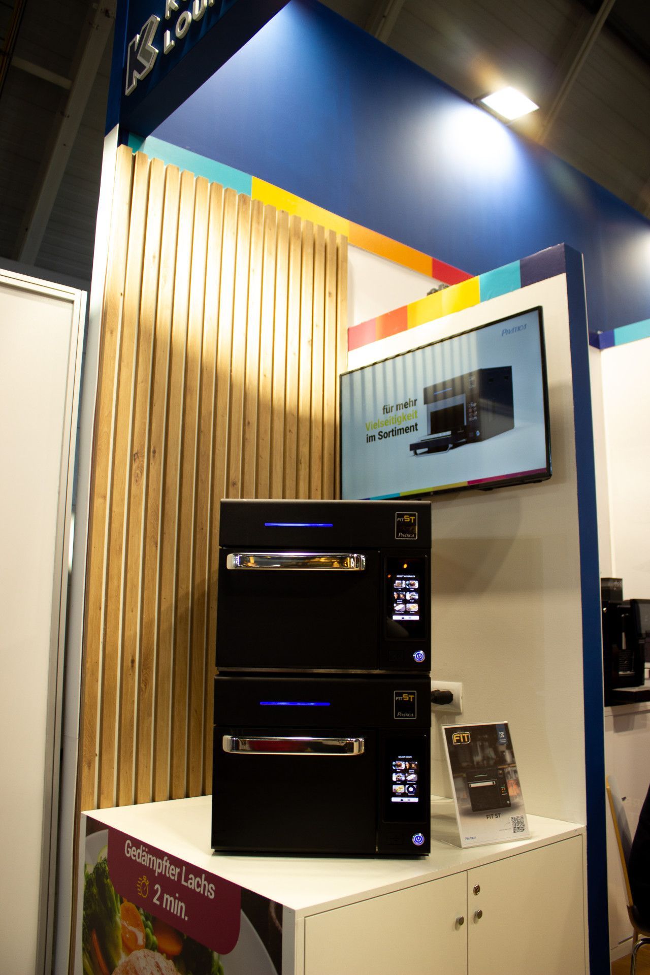 Dois fornos pretos estão empilhados um em cima do outro em uma sala.