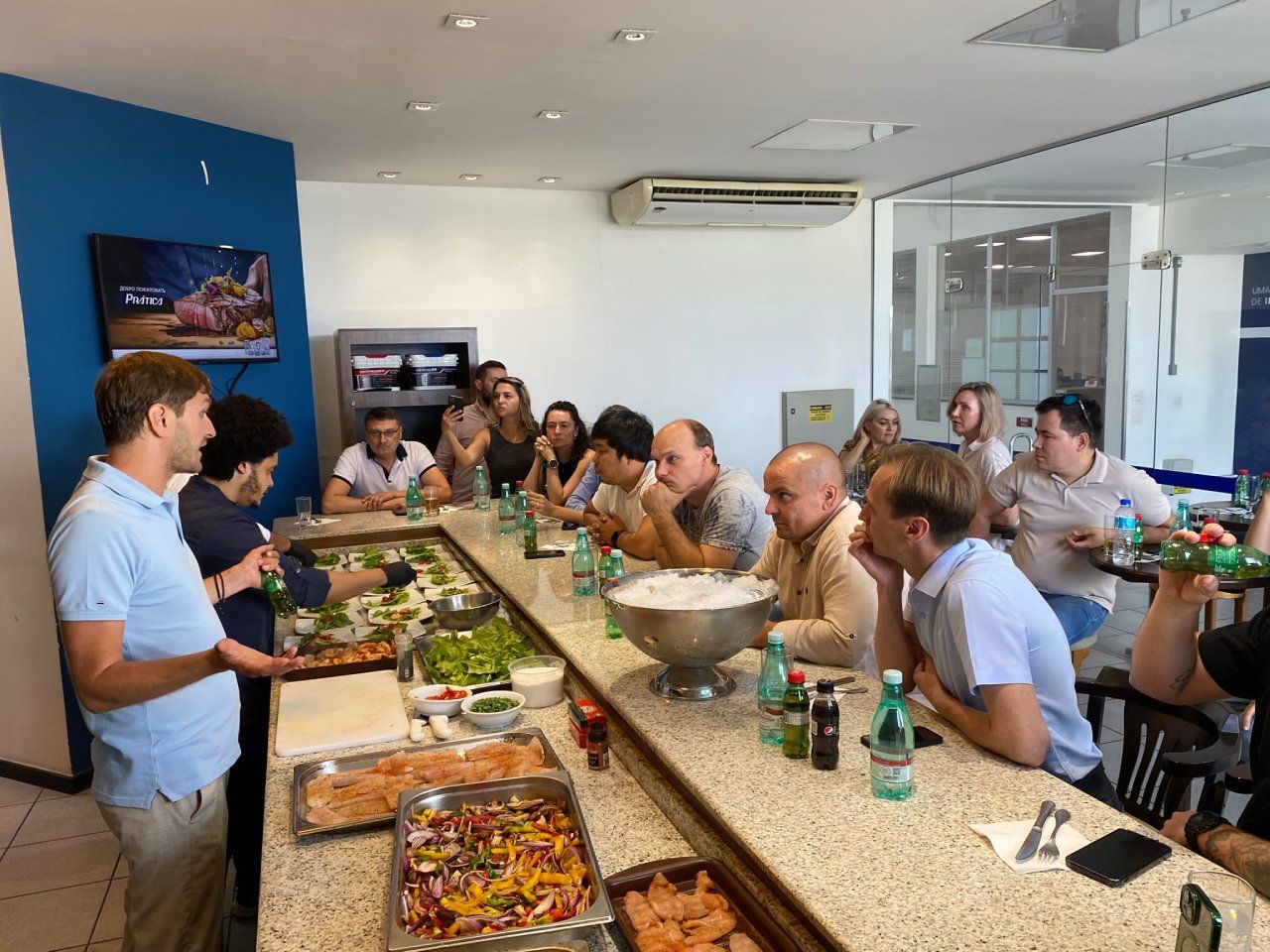 Um grupo de pessoas está sentado à mesa comendo.