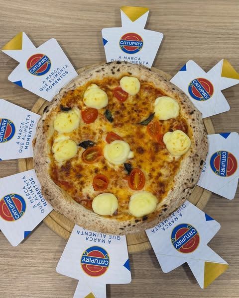 Uma pizza em uma tábua de corte de madeira cercada por cartões que dizem centurião