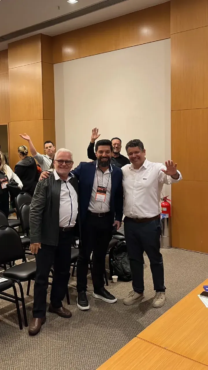 Um grupo de homens está posando para uma foto em uma sala.