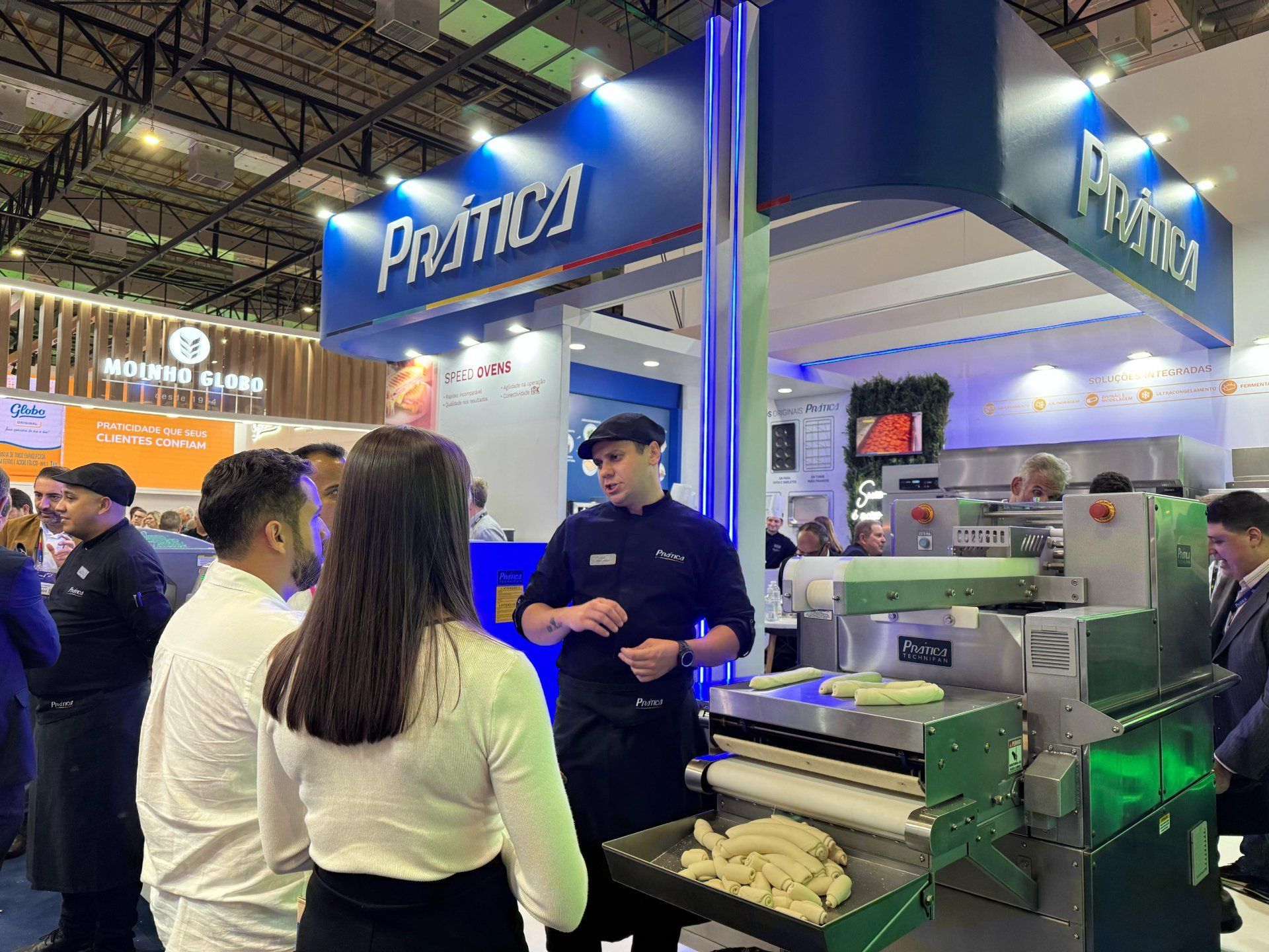 Um grupo de pessoas está em volta de uma máquina em uma convenção.