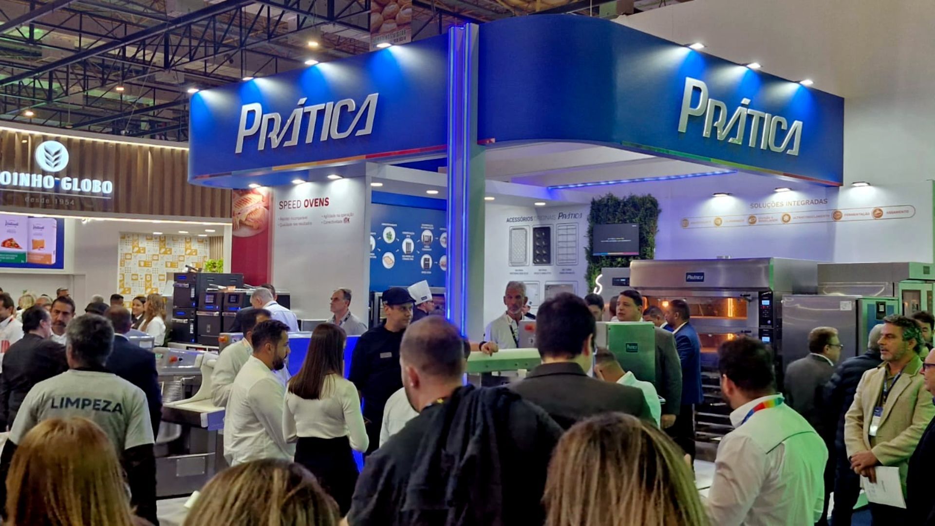 Um grupo de pessoas está em frente a um estande em uma convenção.