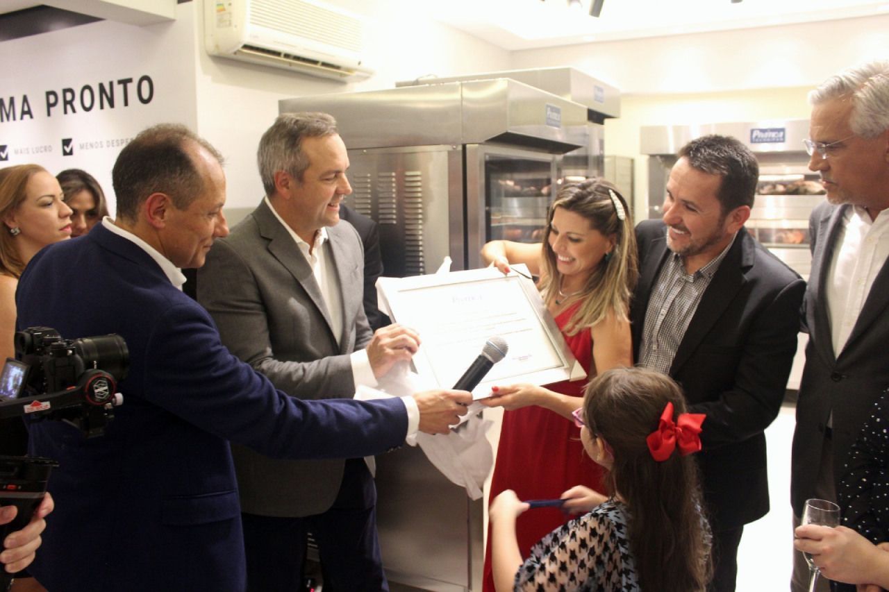 Um grupo de pessoas está em uma sala com uma placa que diz ma pronto