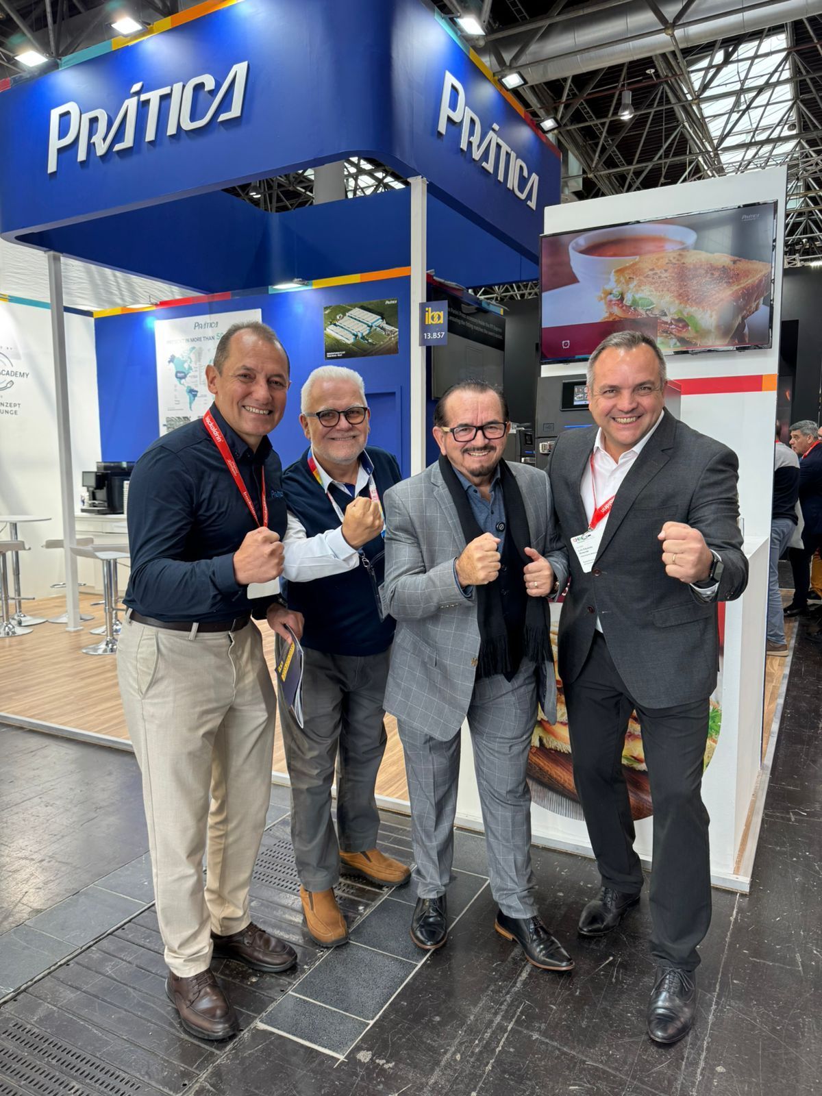 Um grupo de homens está posando para uma foto em uma convenção.