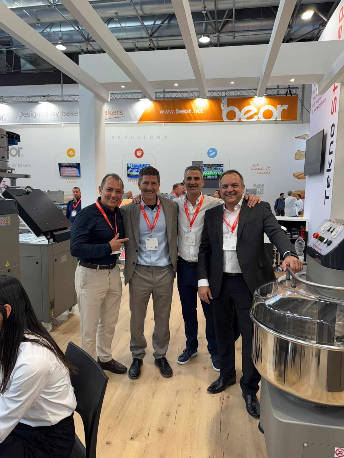 Um grupo de homens está posando para uma foto em frente a uma máquina.