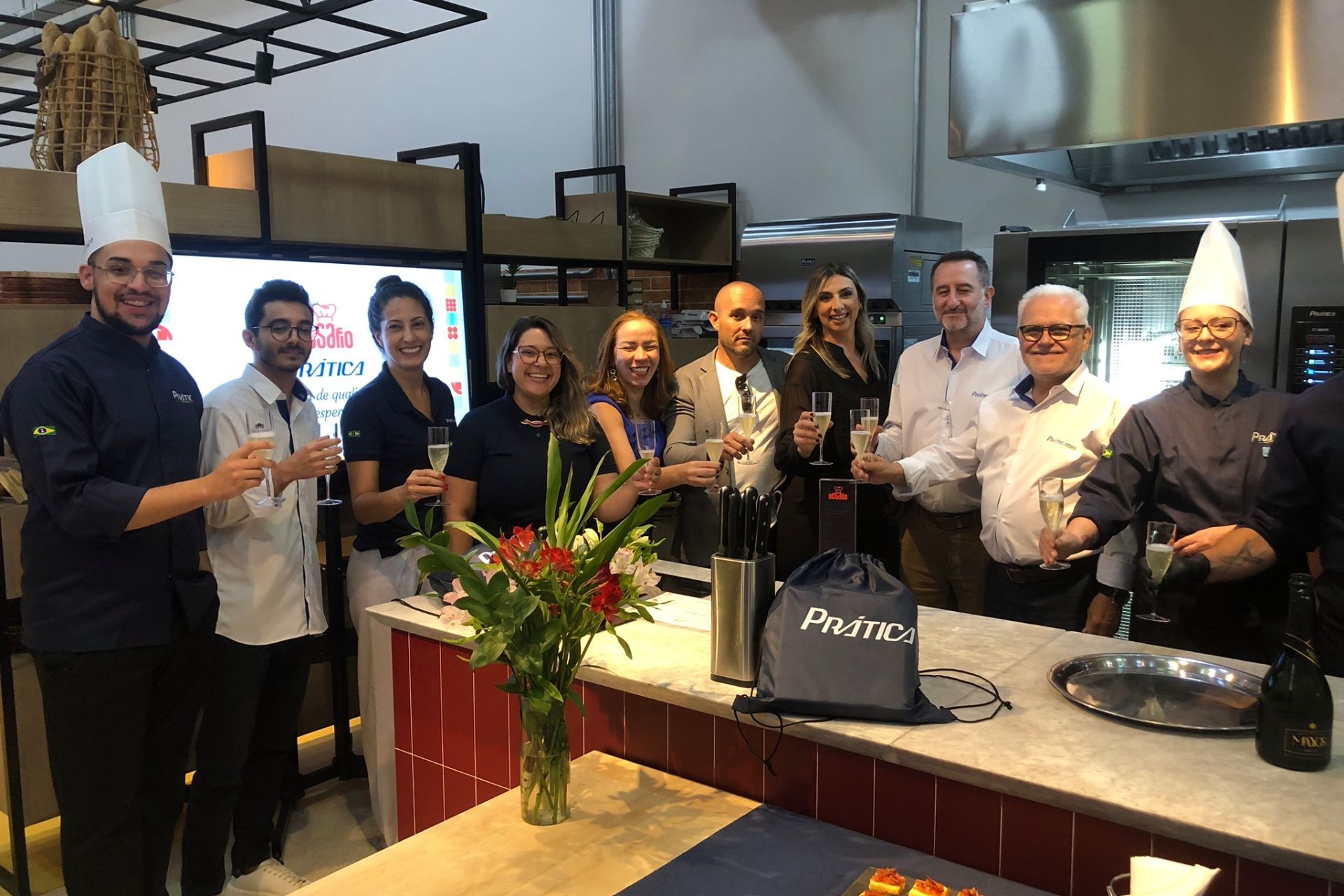 Grupo de pessoas brindando com champanhe em uma cozinha