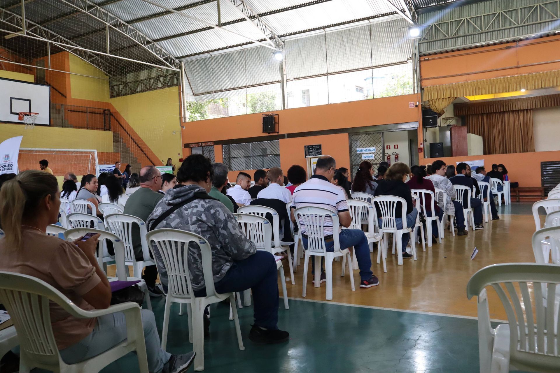 Um grupo de pessoas está sentado em cadeiras em uma academia.