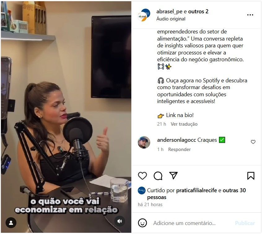 Uma mulher está sentada em frente a um microfone e falando nele.