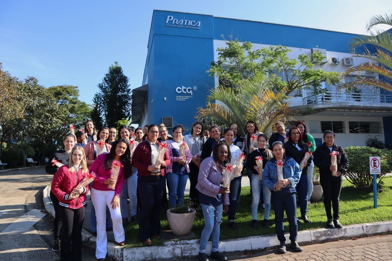 Um grupo de pessoas está posando para uma foto em frente a um prédio.