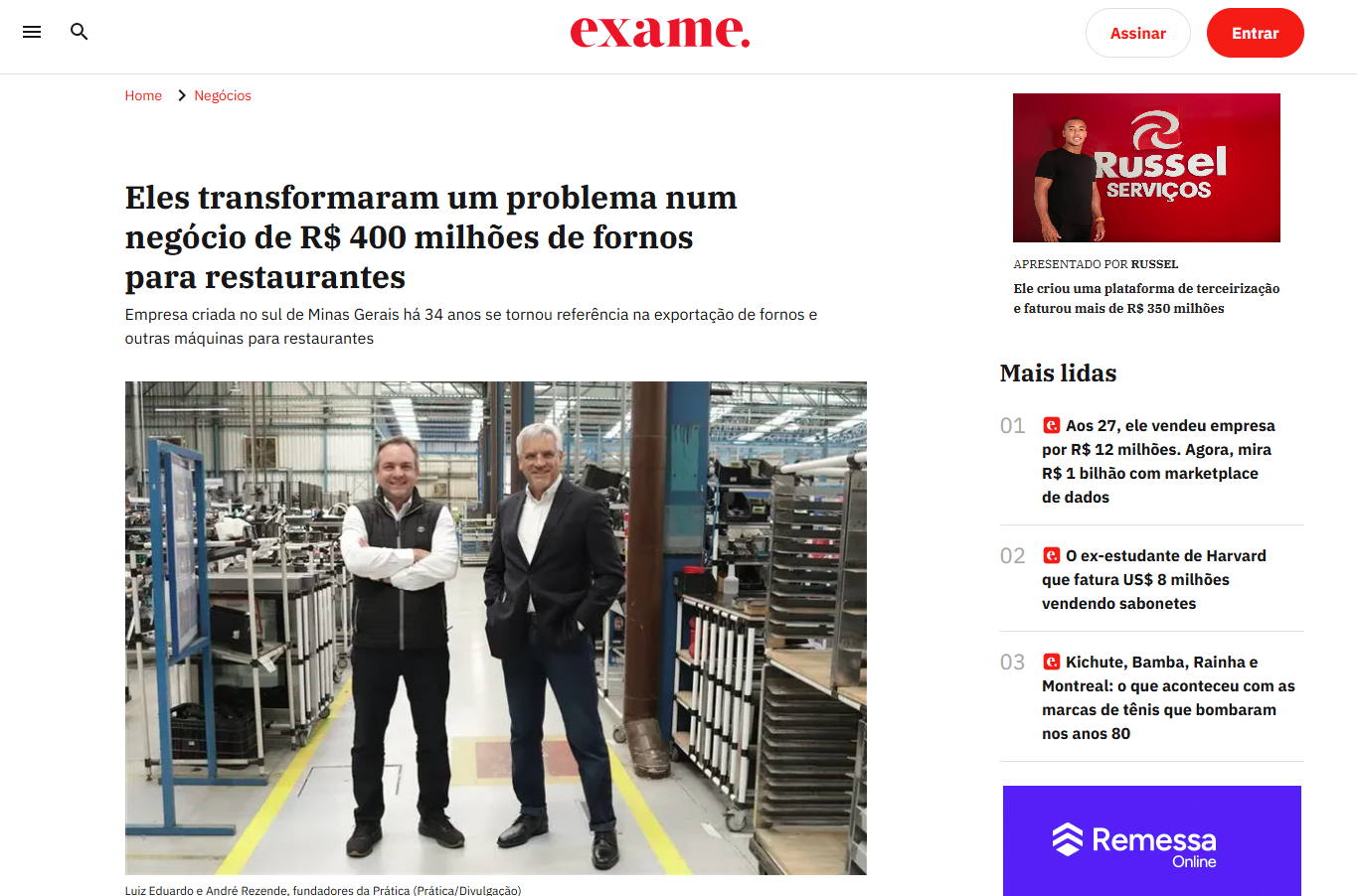 Dois homens estão parados um ao lado do outro em uma fábrica.