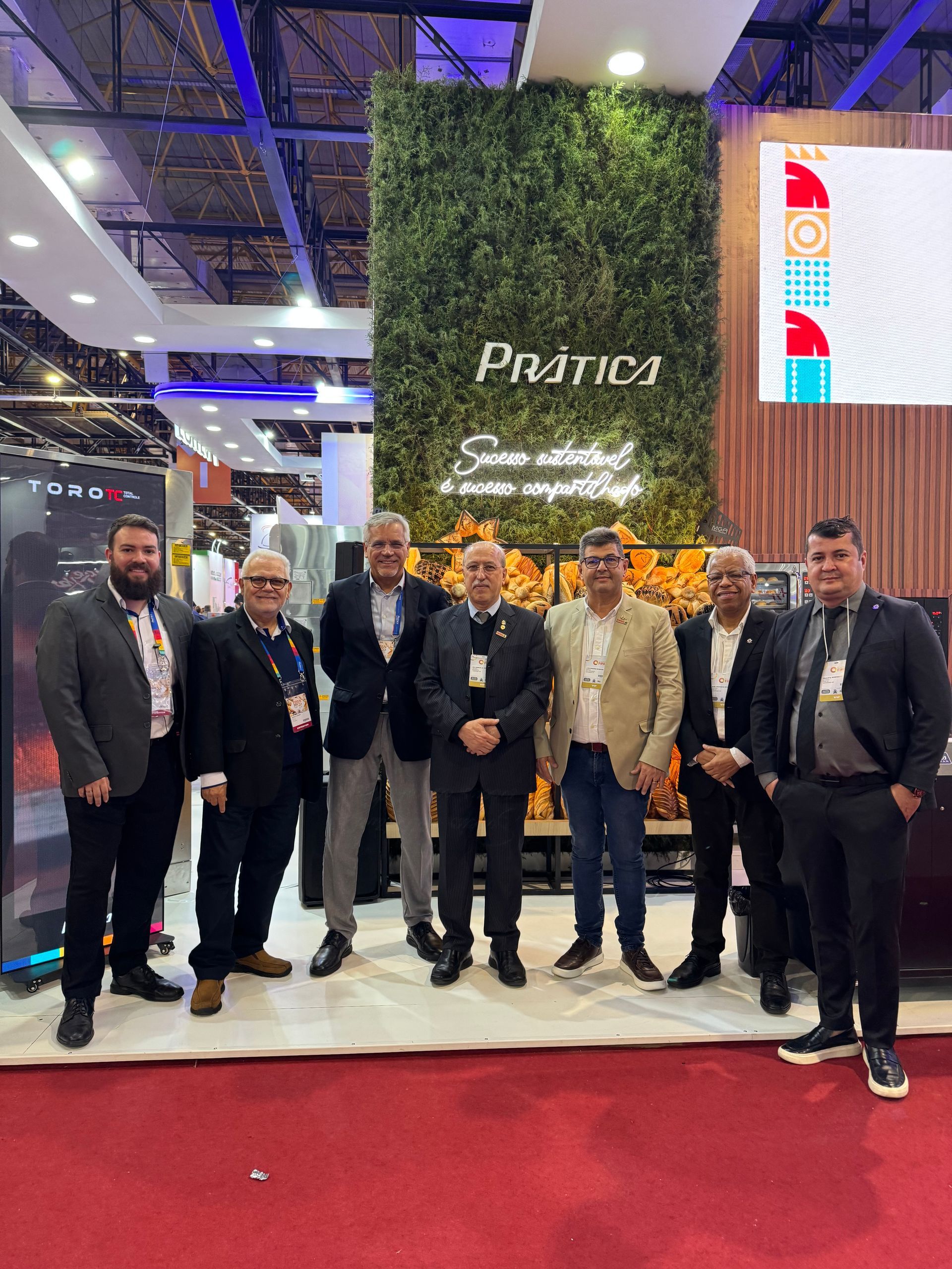 Um grupo de homens está posando para uma foto em uma convenção.