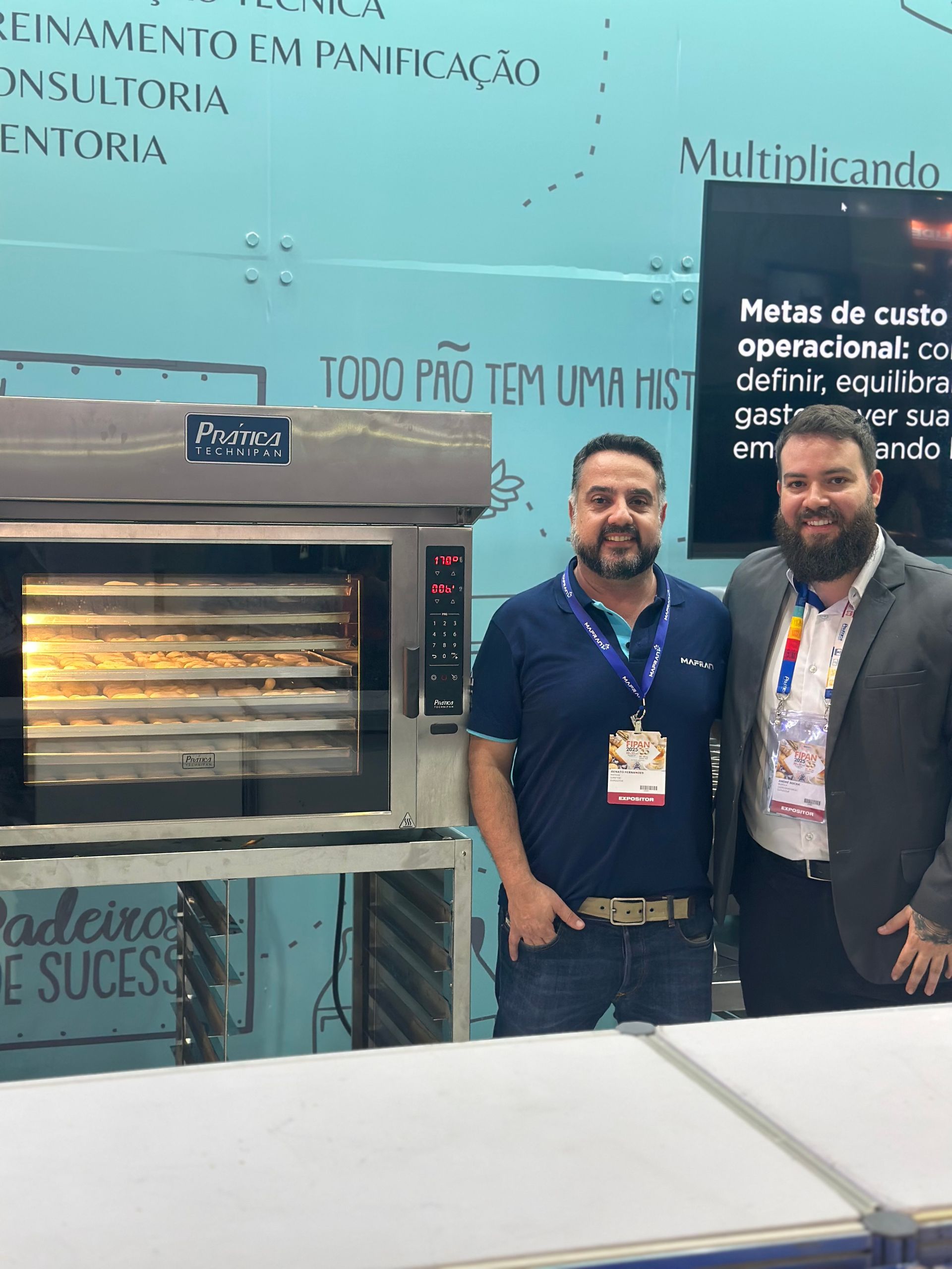 Dois homens em pé em frente a um forno que diz todo pro tem uma hist